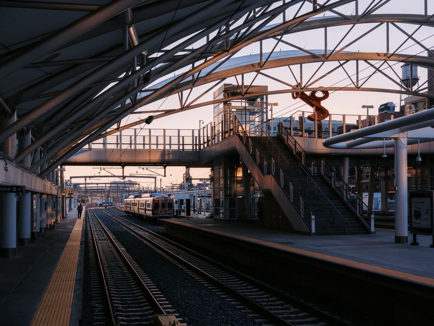 Empty train platform with curved roof structure extending into the distance.
