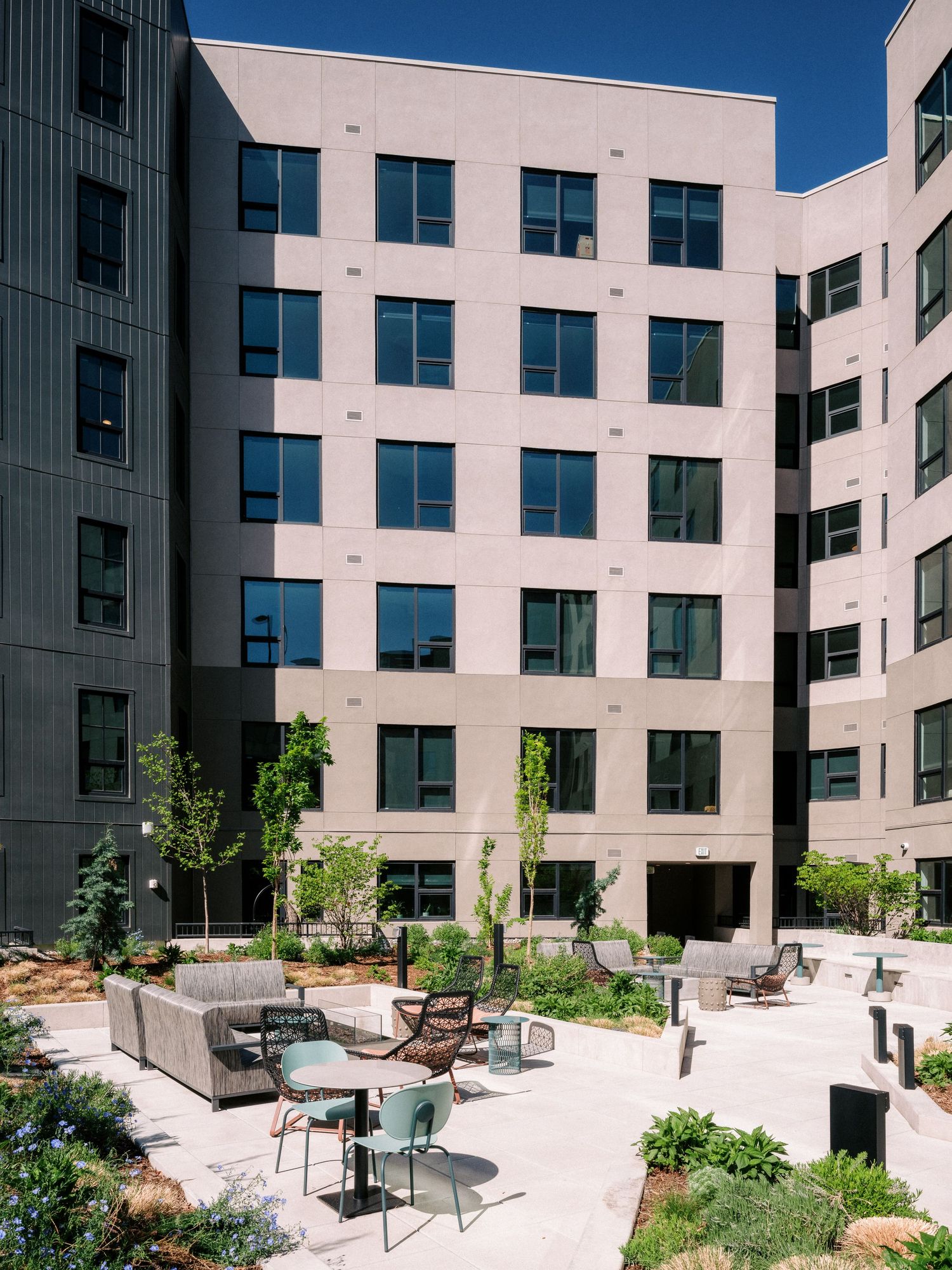 Modern building courtyard with outdoor seating and landscaped garden areas.