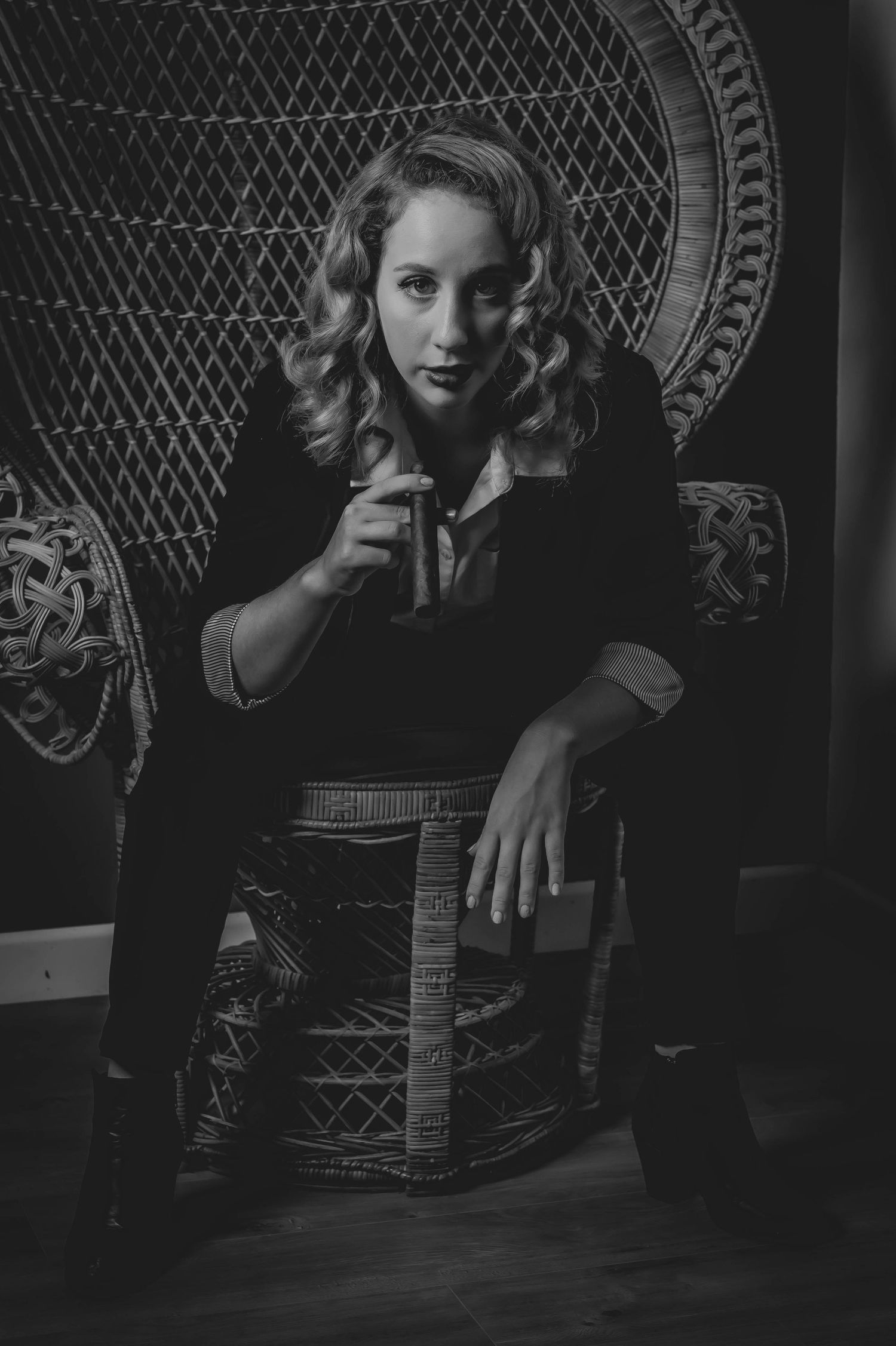 Dramatic black and white photo with ornate wicker chair detail.