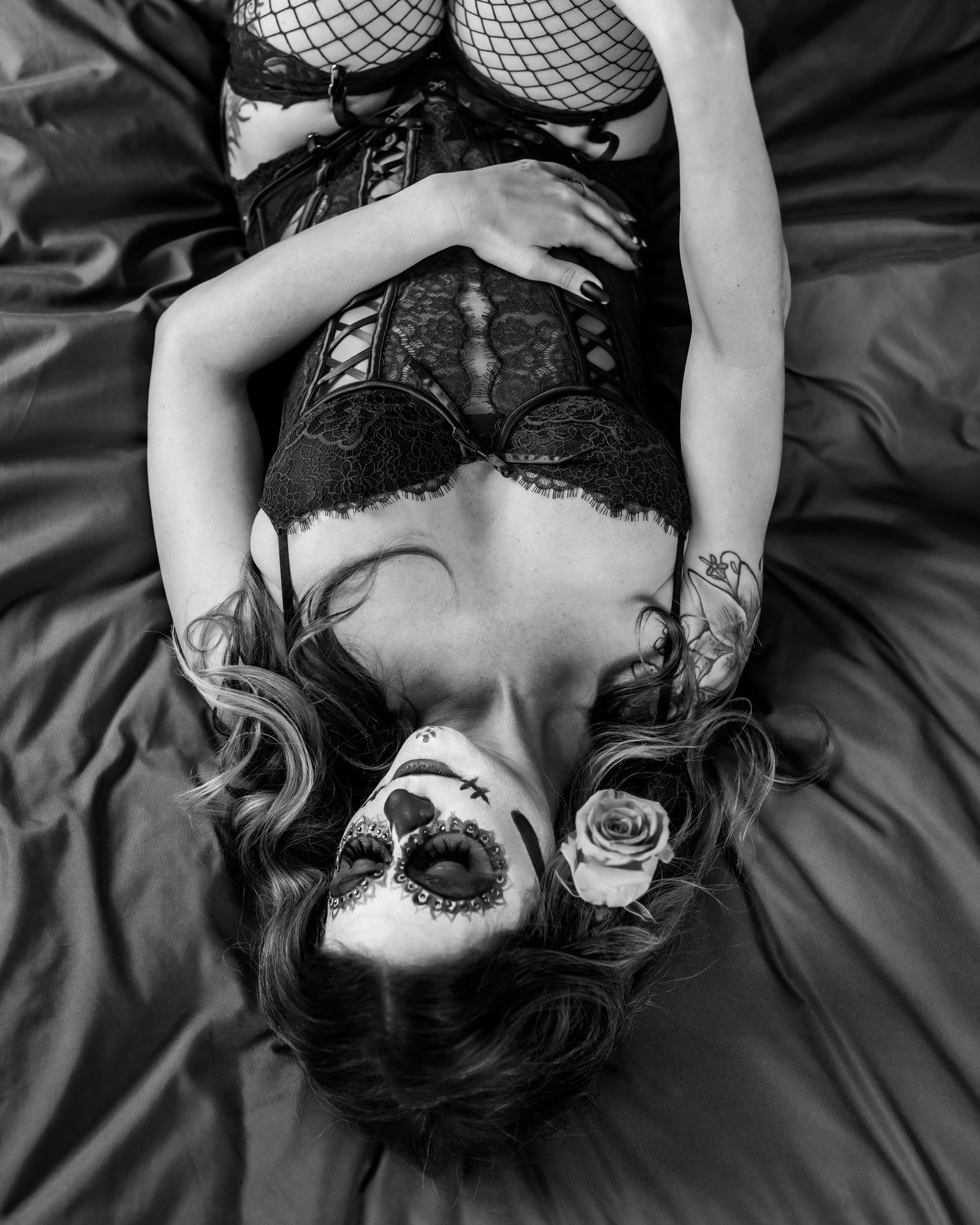 Gothic boudoir portrait in black and white with lace and fishnet details.