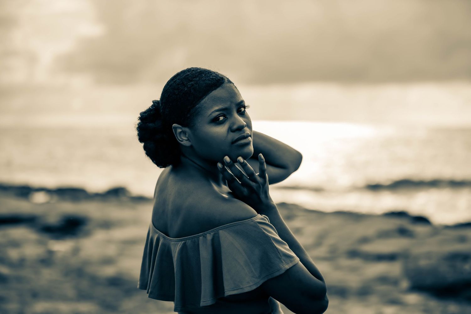 Sepia-toned coastal portrait series with dramatic lighting and ocean backdrop.