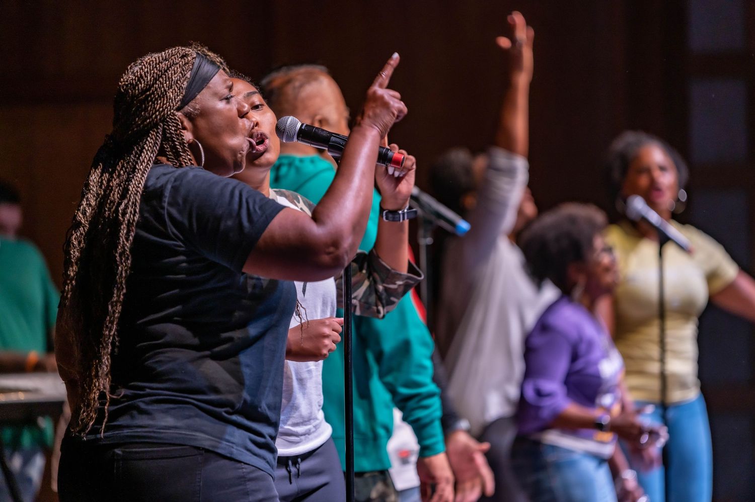 Gospel choir performers singing passionately during an emotional performance.