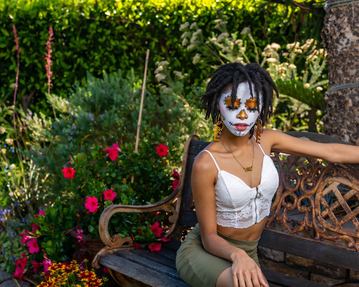 Garden portrait session with decorative bench and red roses in background.