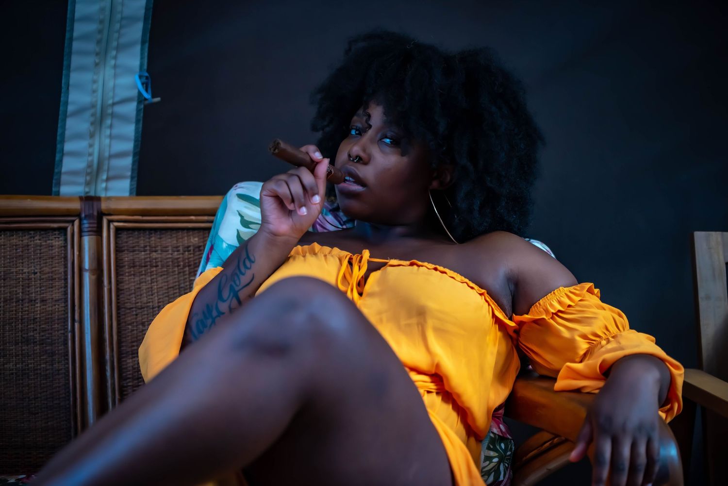 Dramatic portrait in yellow dress against dark background.