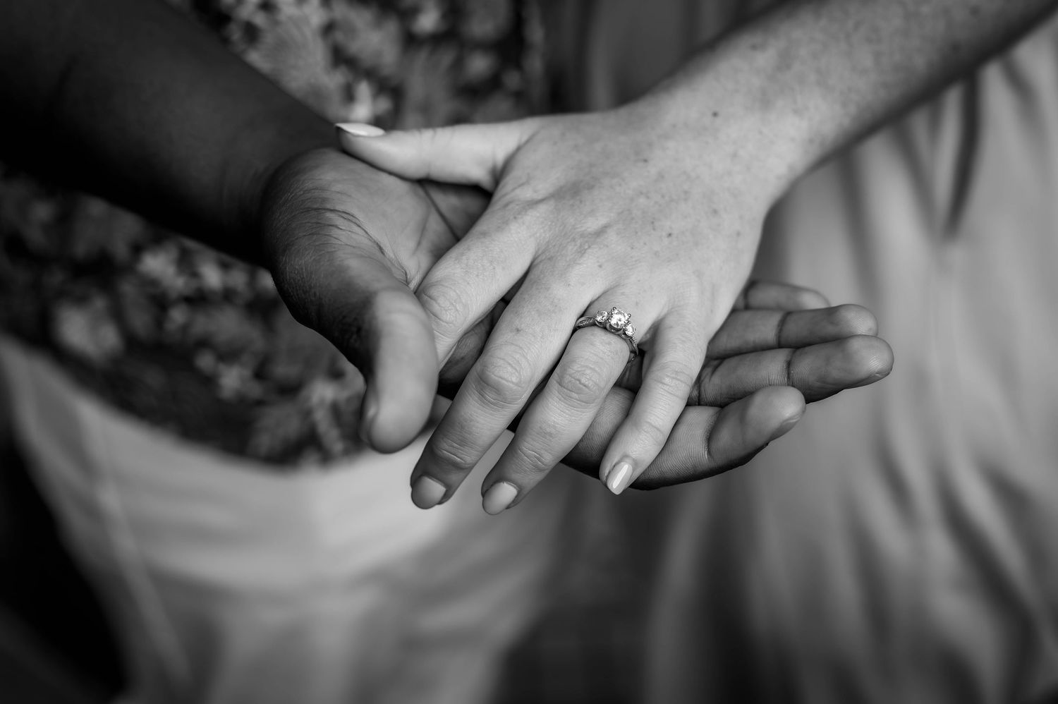 Close-up black and white photos of hands with wedding rings.
