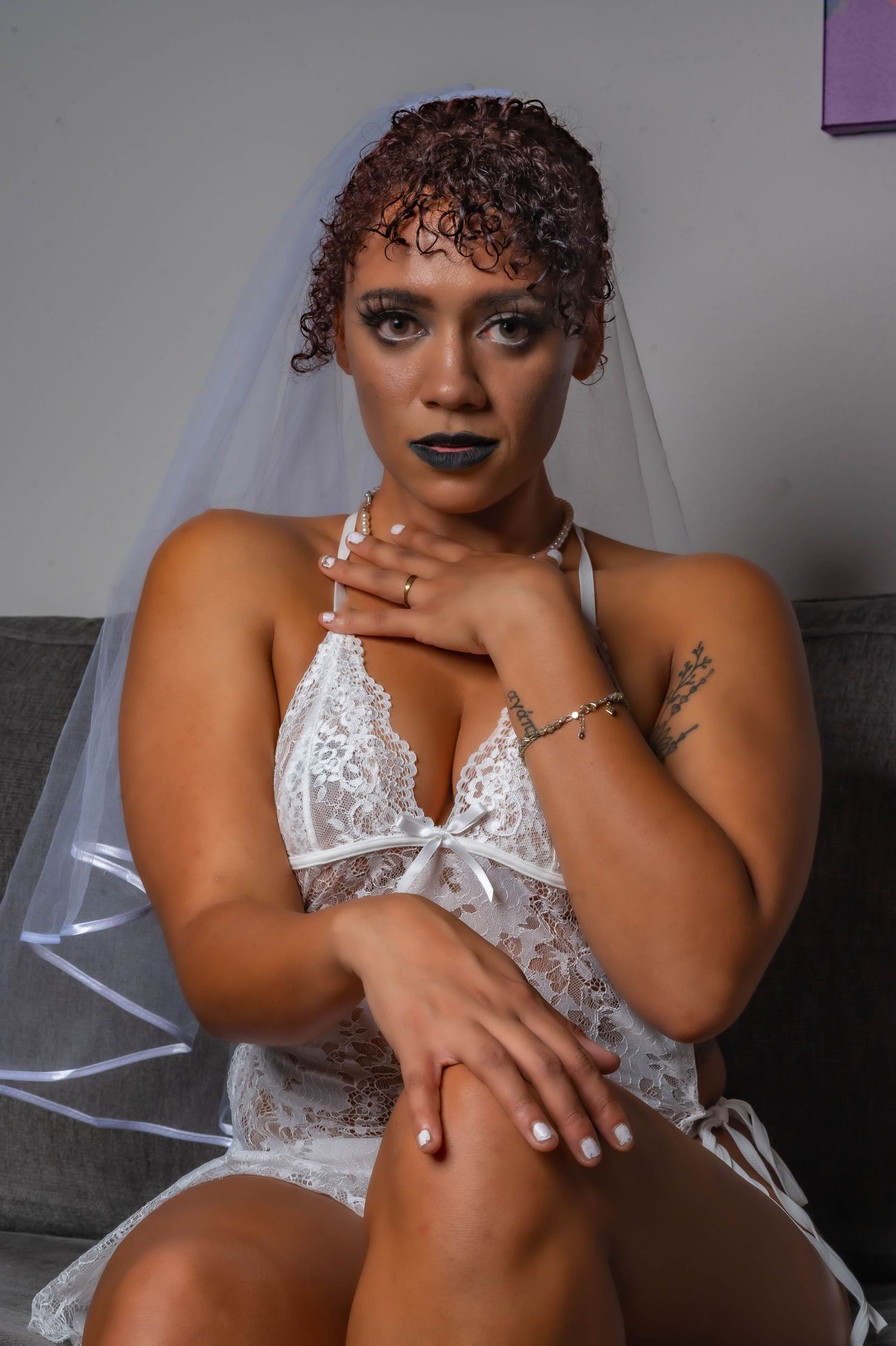 Bridal boudoir portrait featuring white lace and veil details.