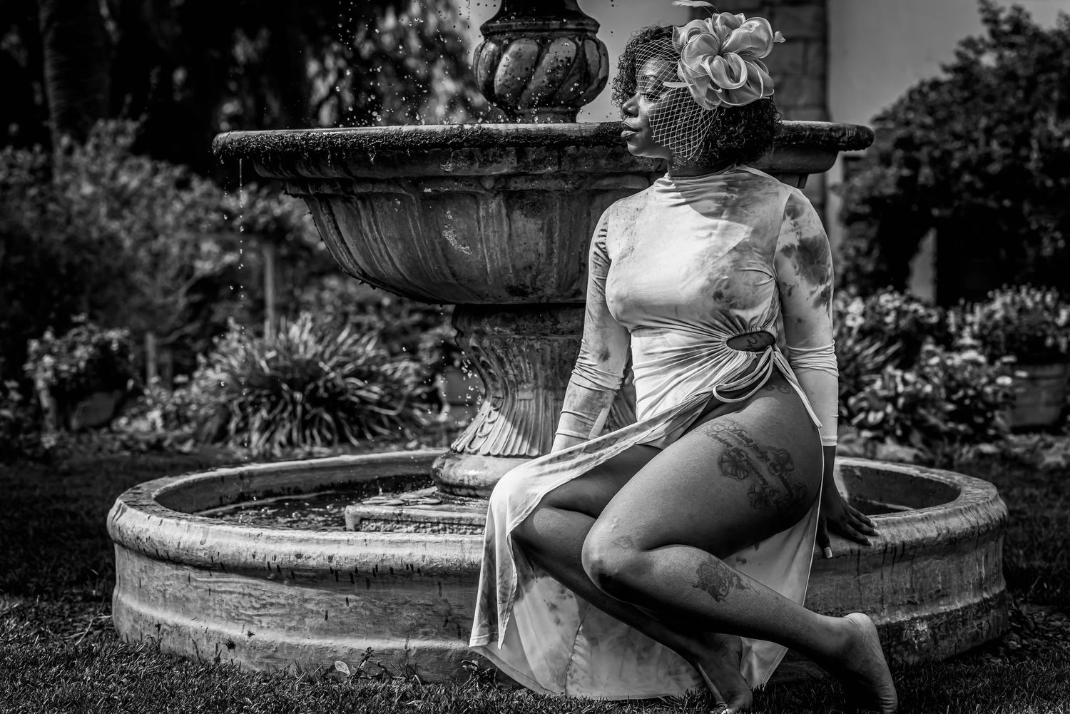 Person in white dress poses on stone wall in black and white outdoor portrait series.