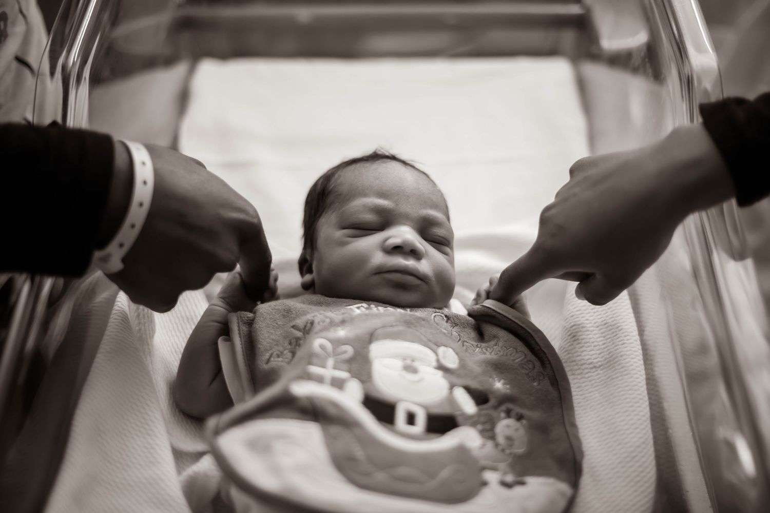 Close-up shots of gentle hands cradling and caring for a newborn baby.