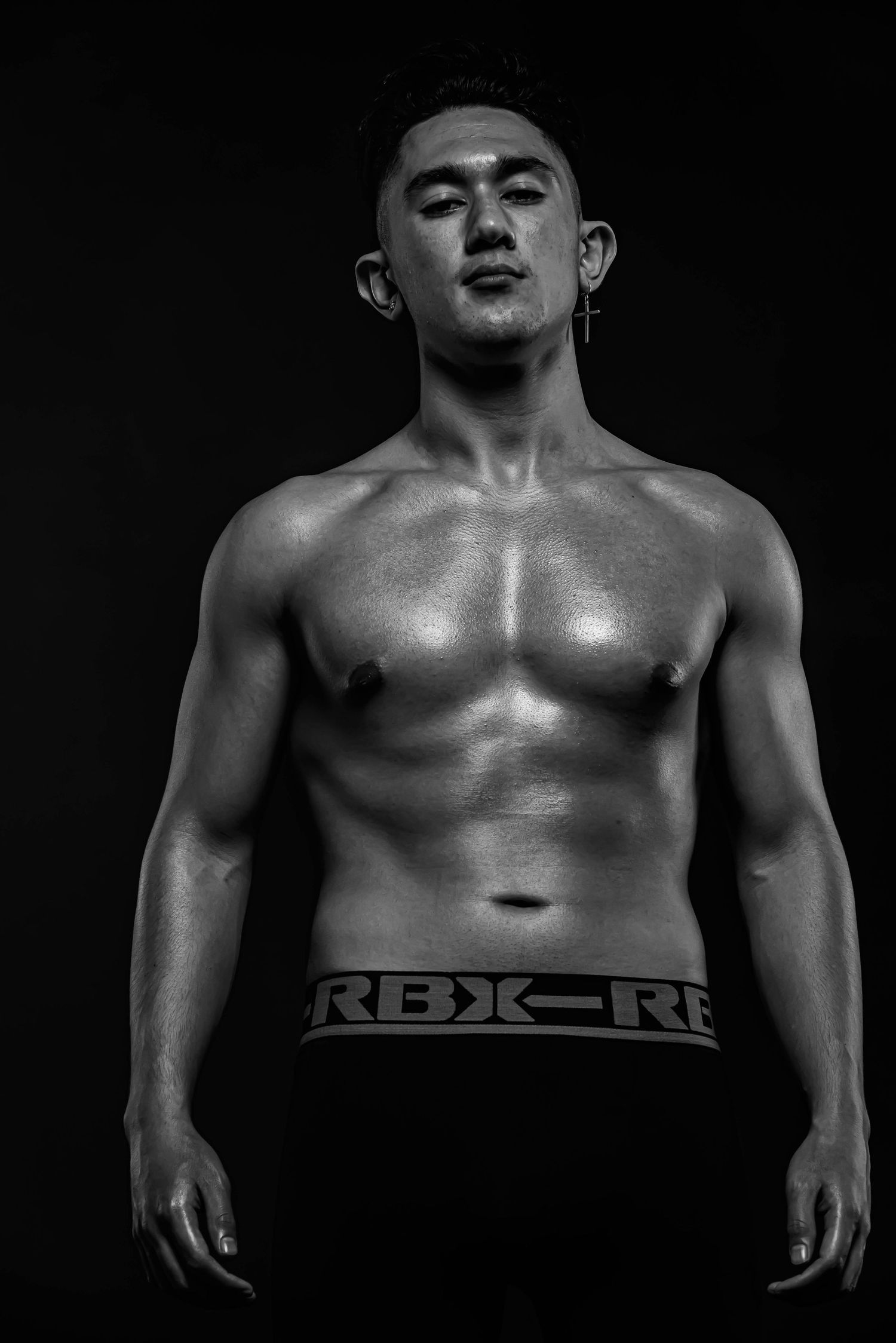 Dramatic black and white fitness photography showing muscular torso.