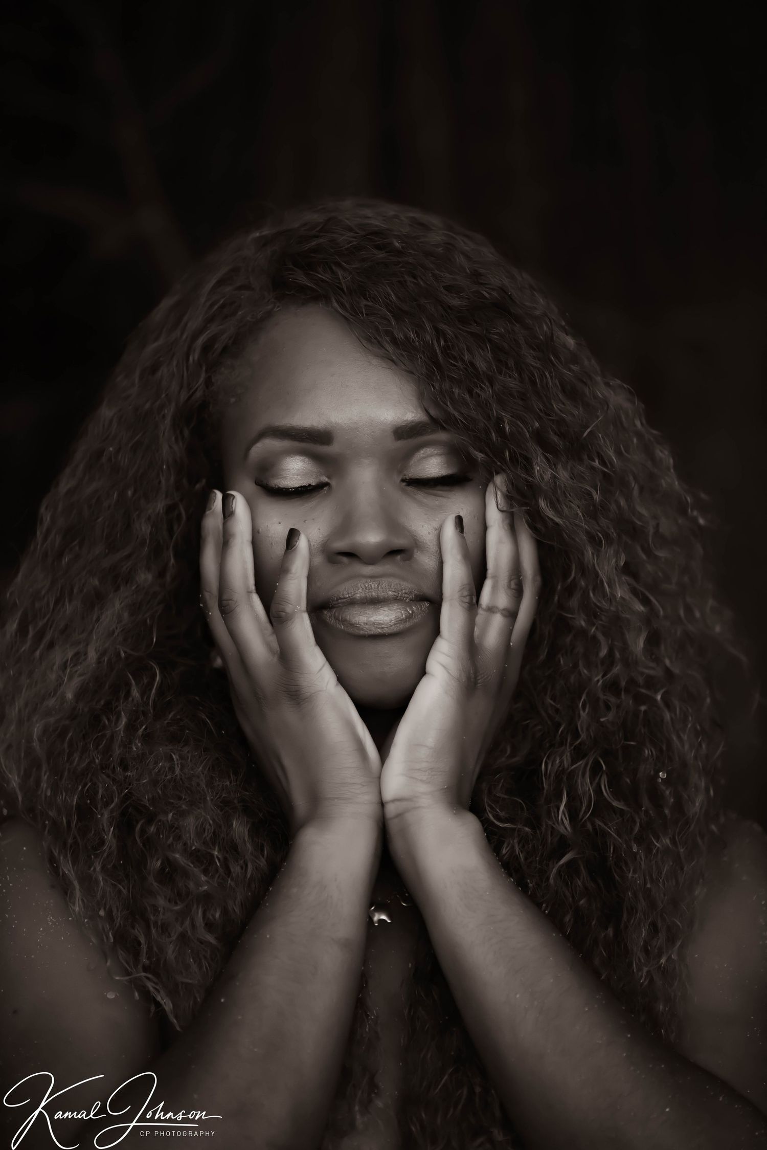Emotive black and white portrait series with hands touching face and curly hair.