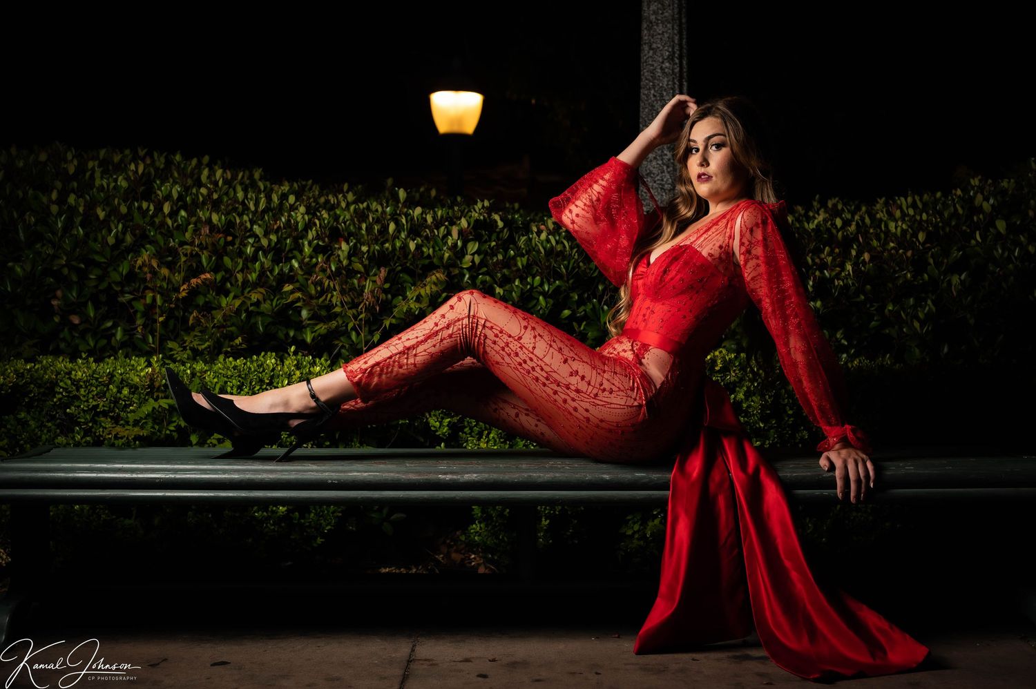 Flowing red gown creates dramatic motion as dancer spins in evening garden setting.