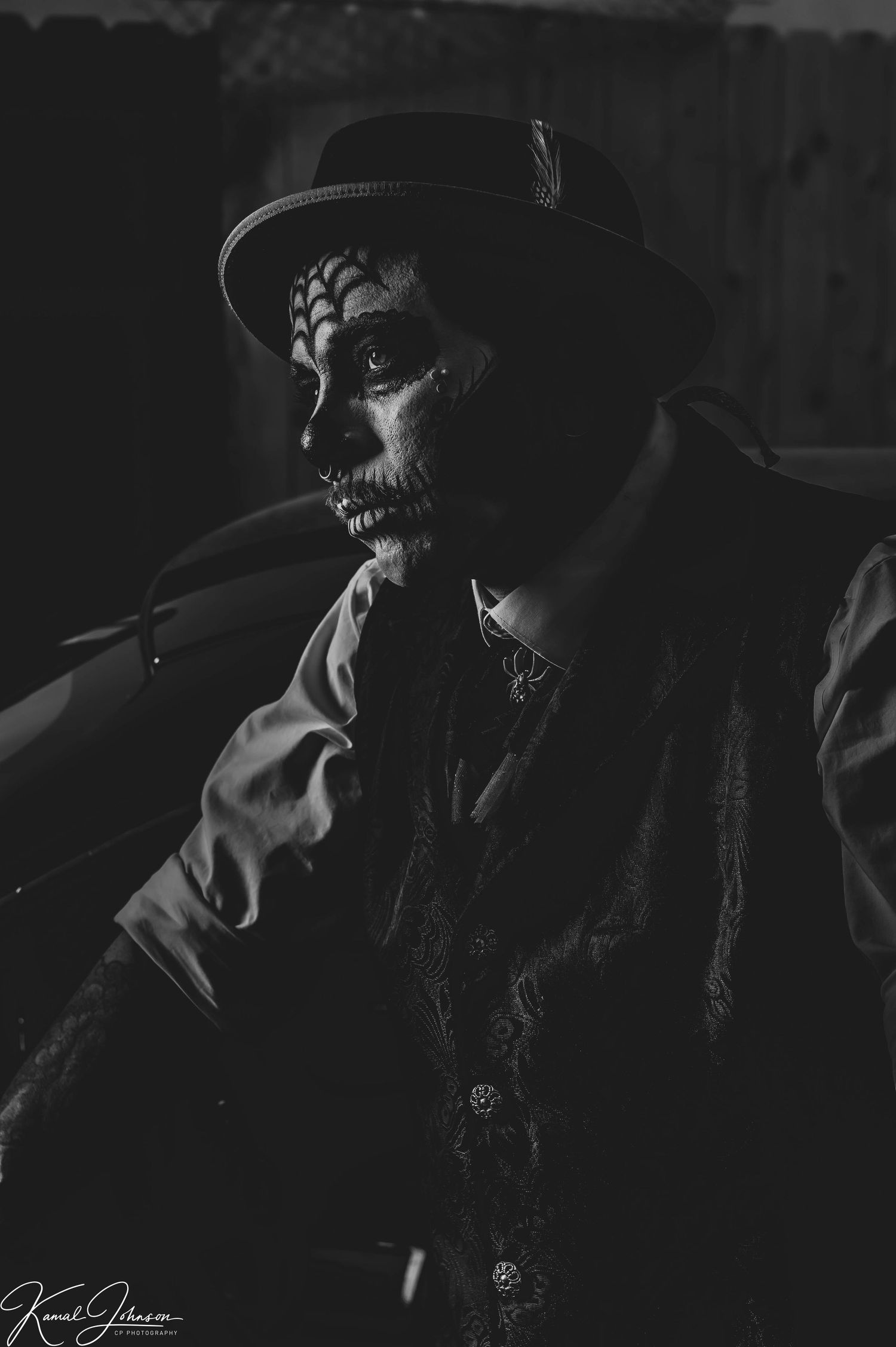 Shadowy film noir portrait with dramatic hat and lighting effects.