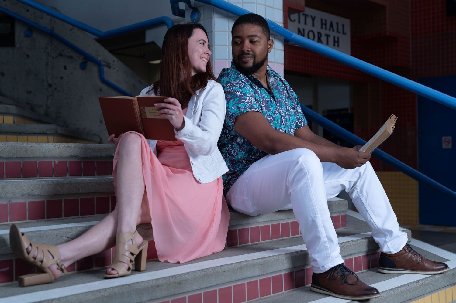 Two people sitting casually on concrete steps having conversation.