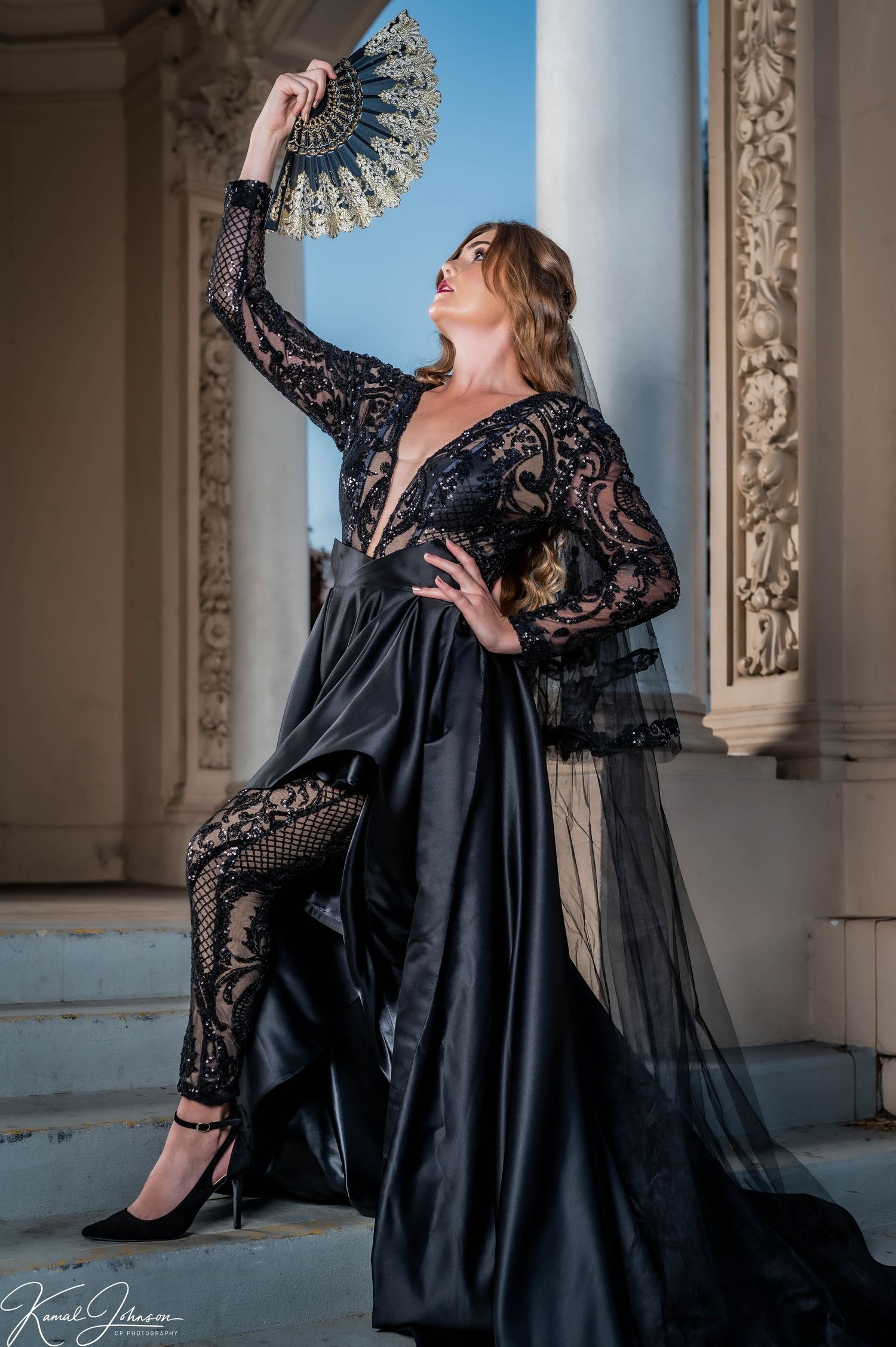 Elegant black lace dress and fan create dramatic poses in classical architectural setting.
