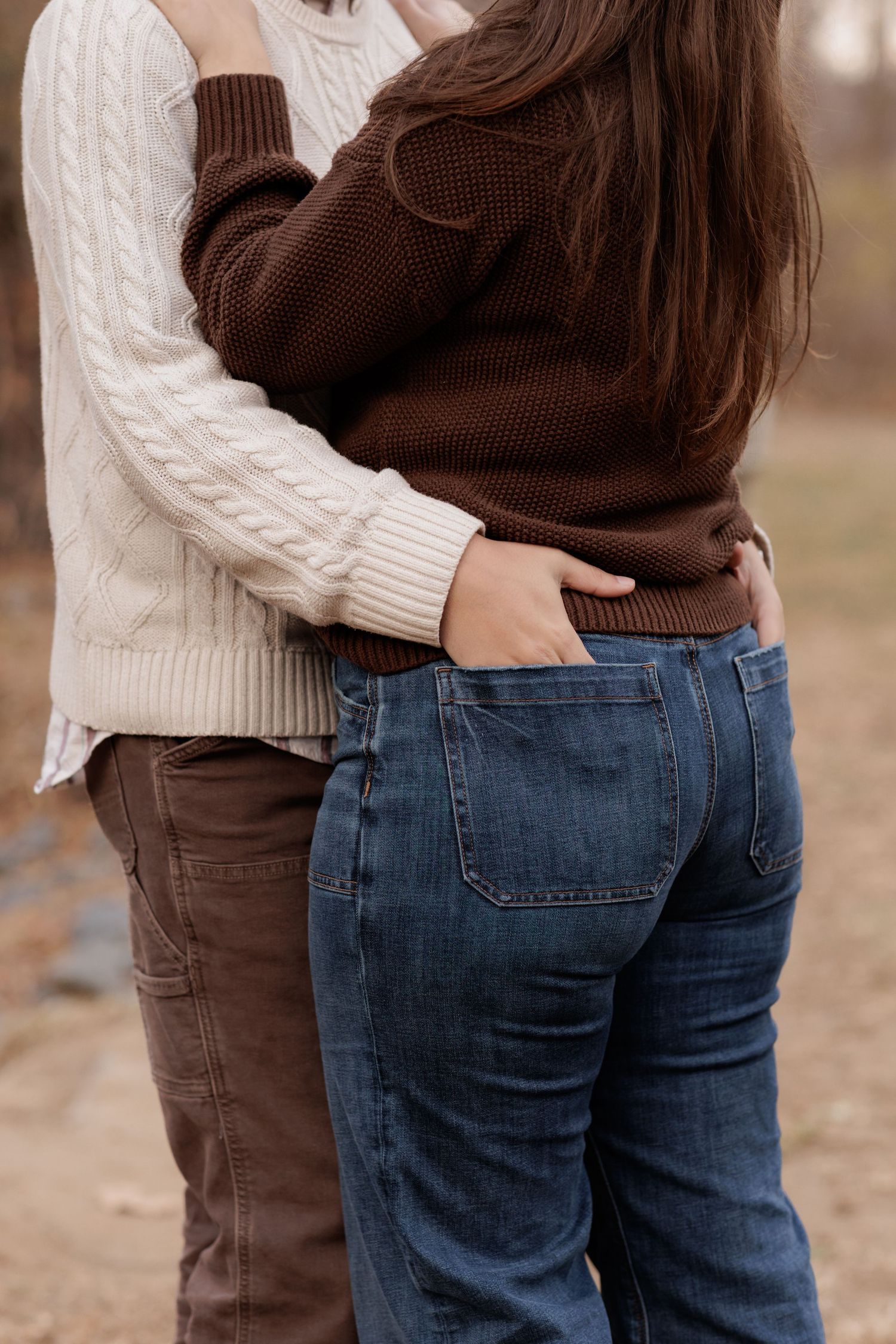Close-up of couple embracing wearing cozy cable knit sweaters.