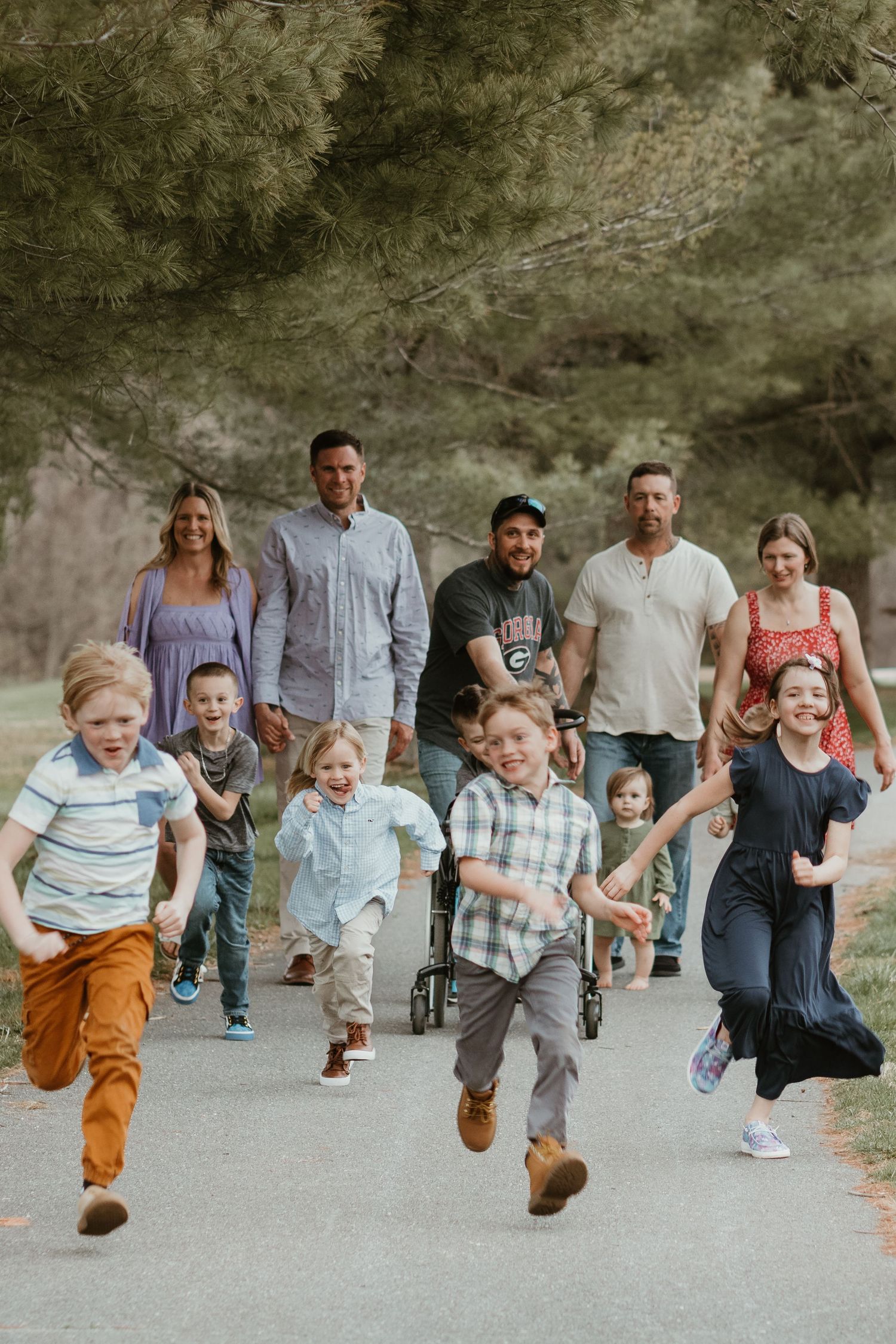 Group running and playing together on a path during a fun outdoor photoshoot.