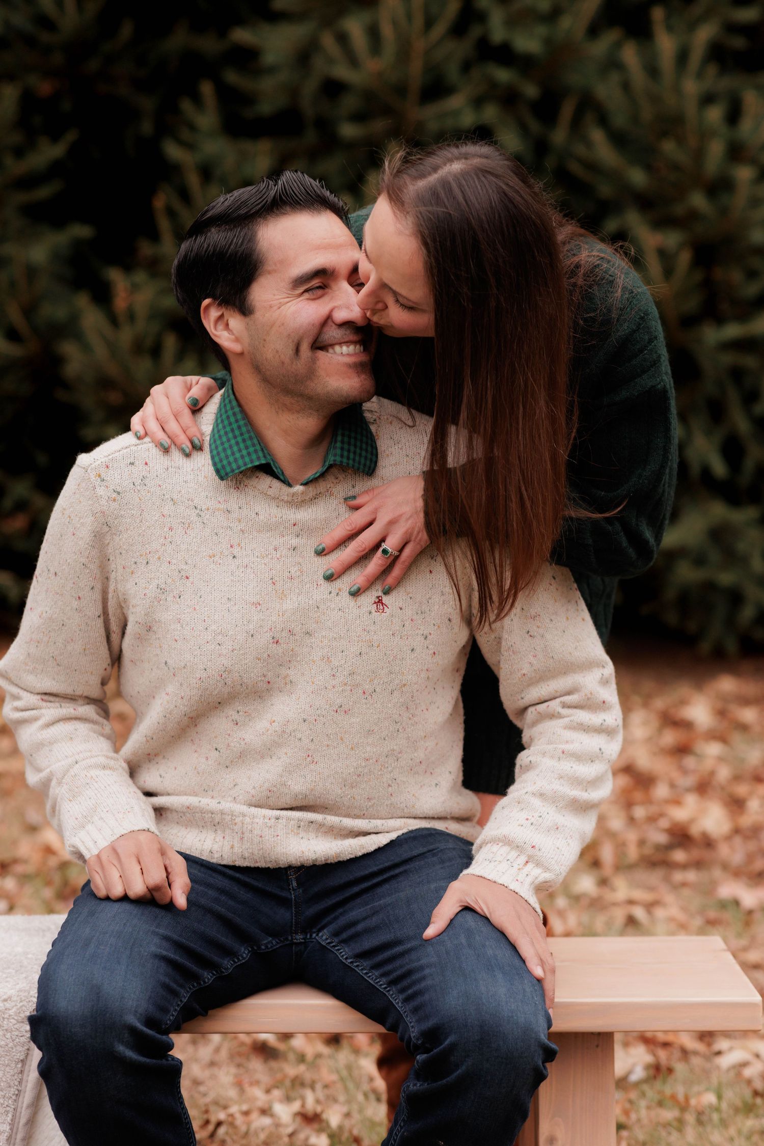 A cozy autumn moment shared between two people on a wooden bench.