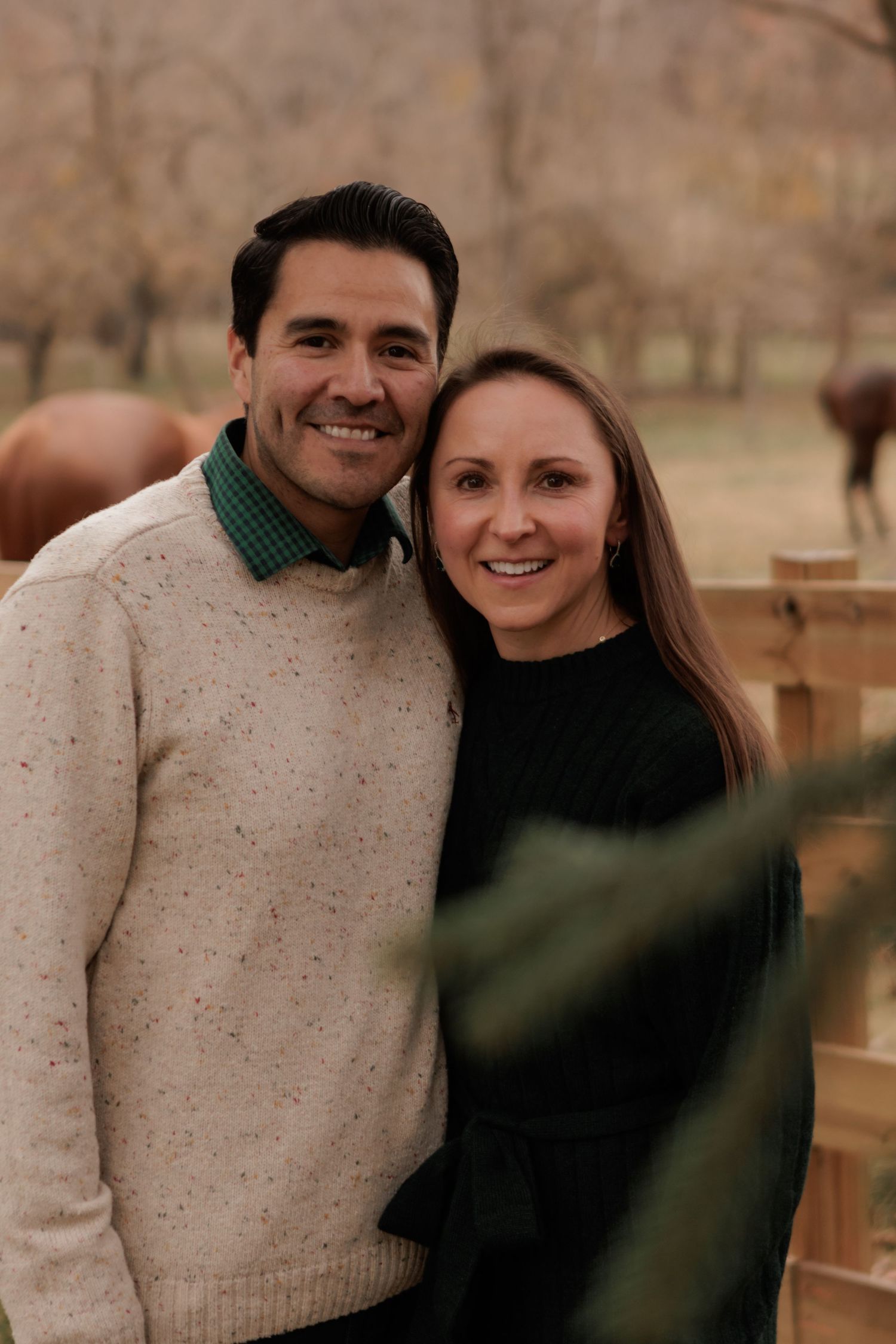 A couple in winter sweaters shares a happy moment during an outdoor photo shoot.