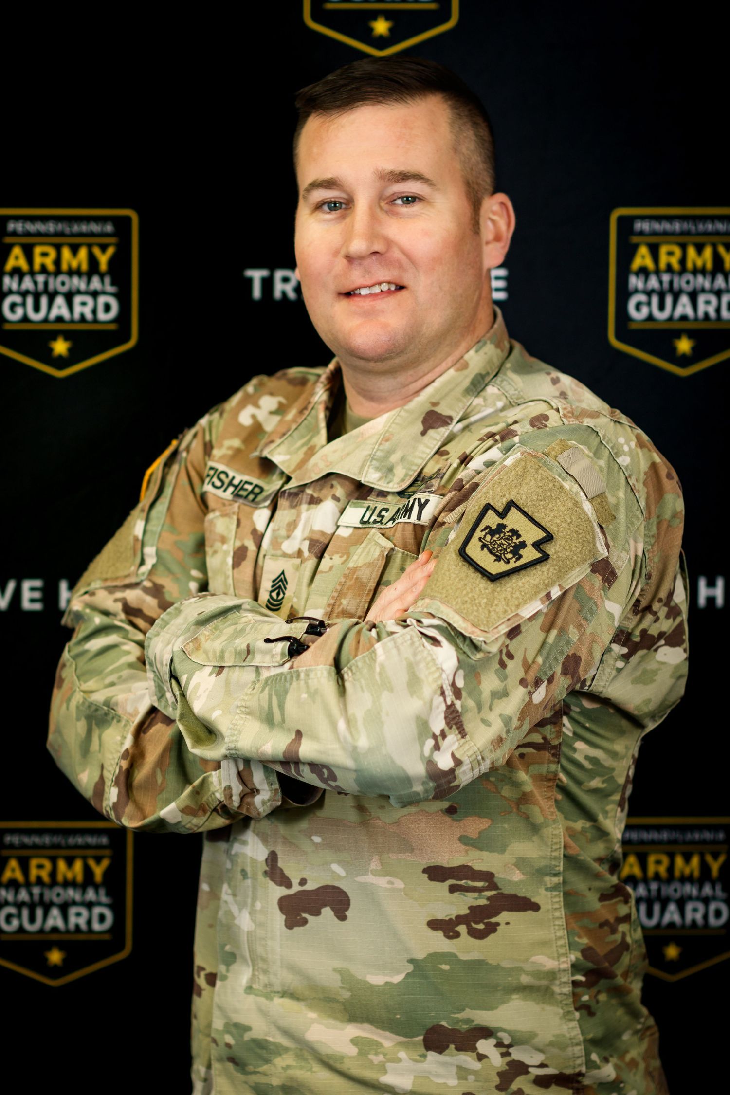 Army National Guard member posing in camouflage uniform for official photos.
