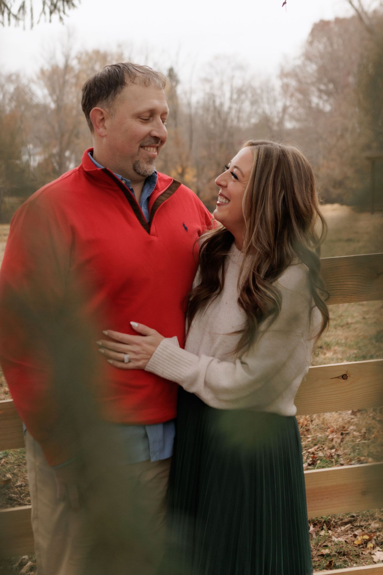 A couple laughs together during a casual outdoor photo session.