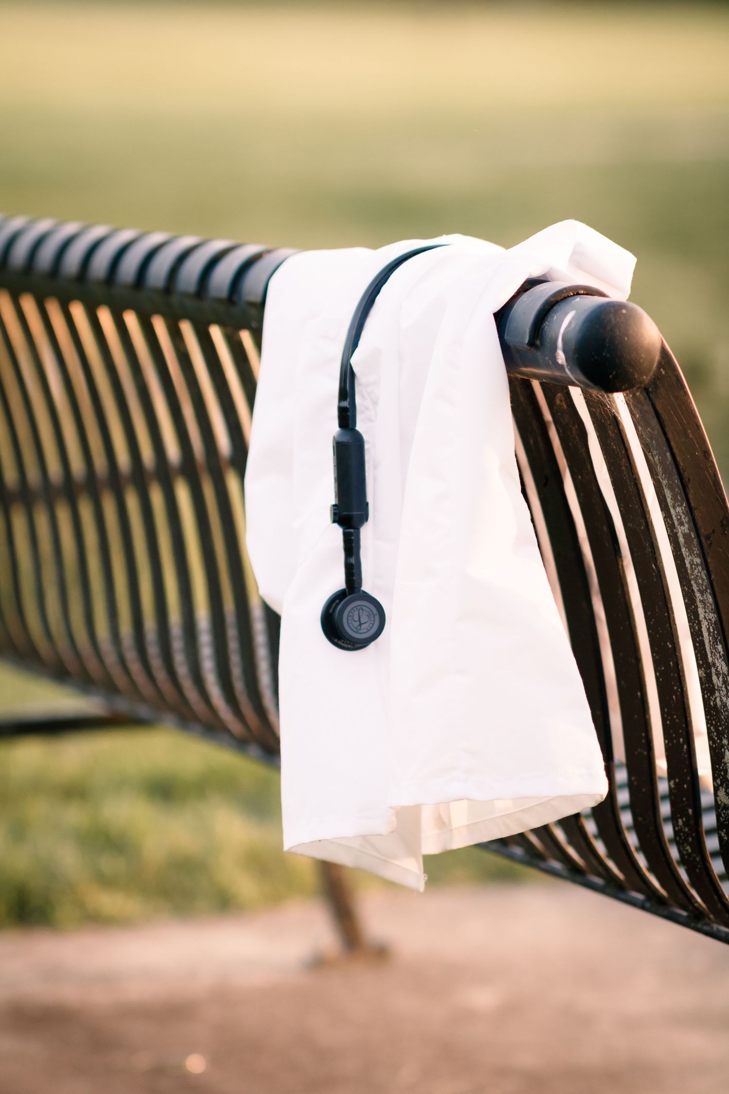 White fabric napkin holder mounted on dark metal park bench outdoors.