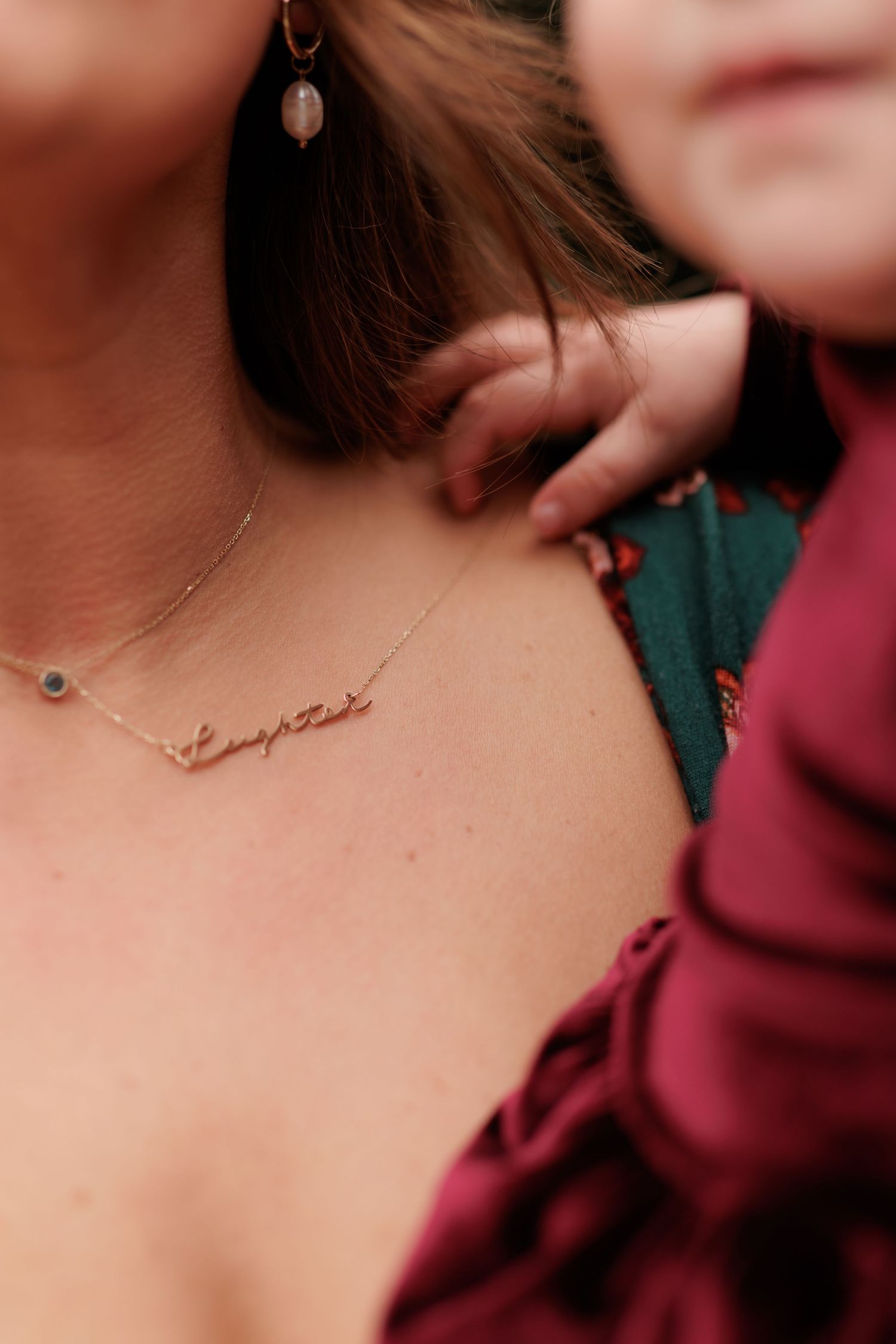 Close-up of a delicate necklace and earring against skin.
