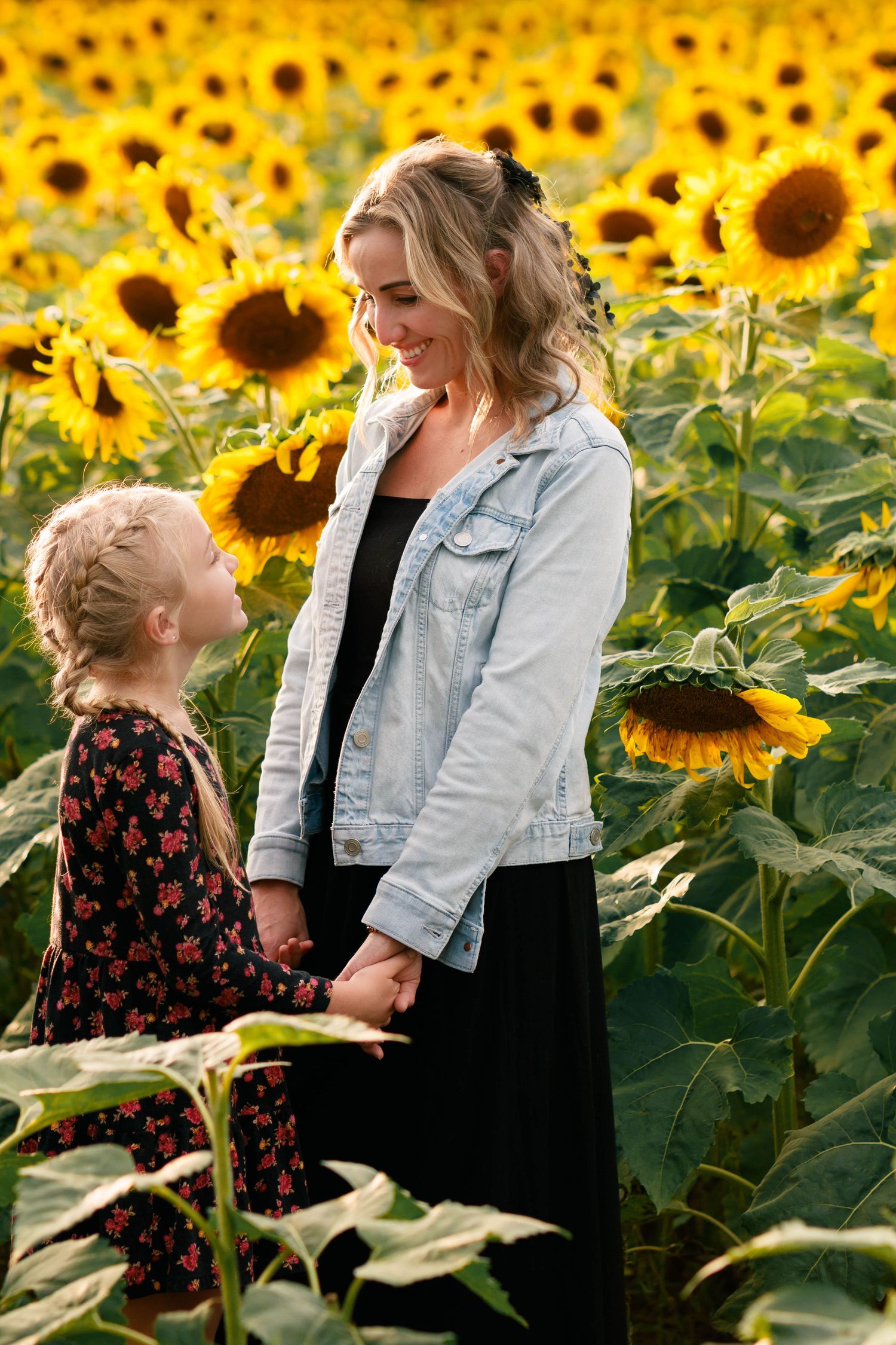 A joyful moment shared in a vibrant sunflower field on a sunny day.
