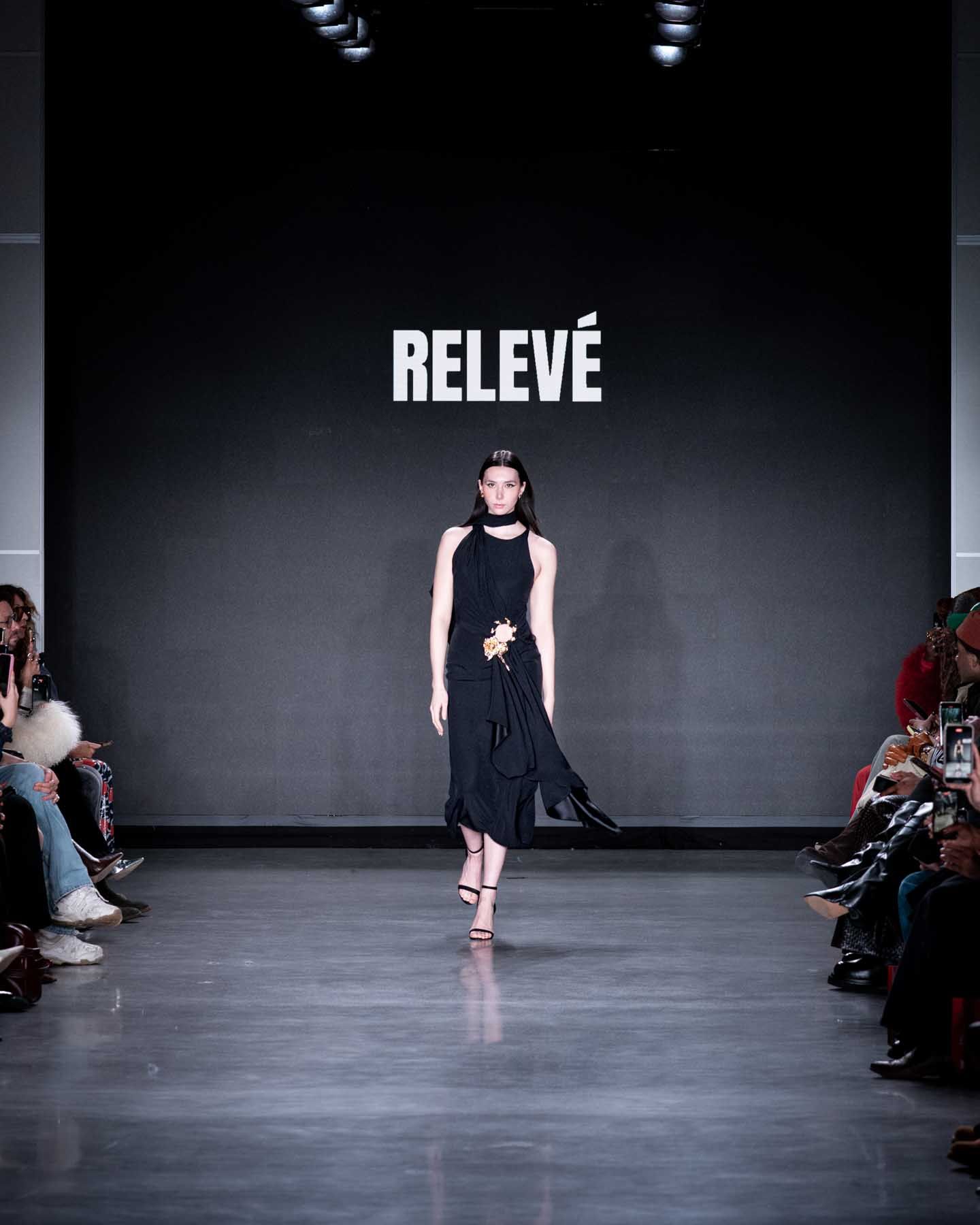Model walks runway in black midi dress at Releve fashion show during NYFW.