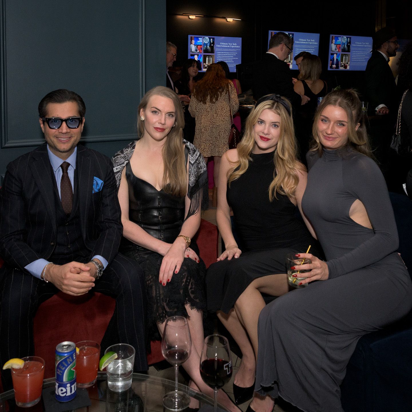 Four guests sit together at elegant evening social event.
