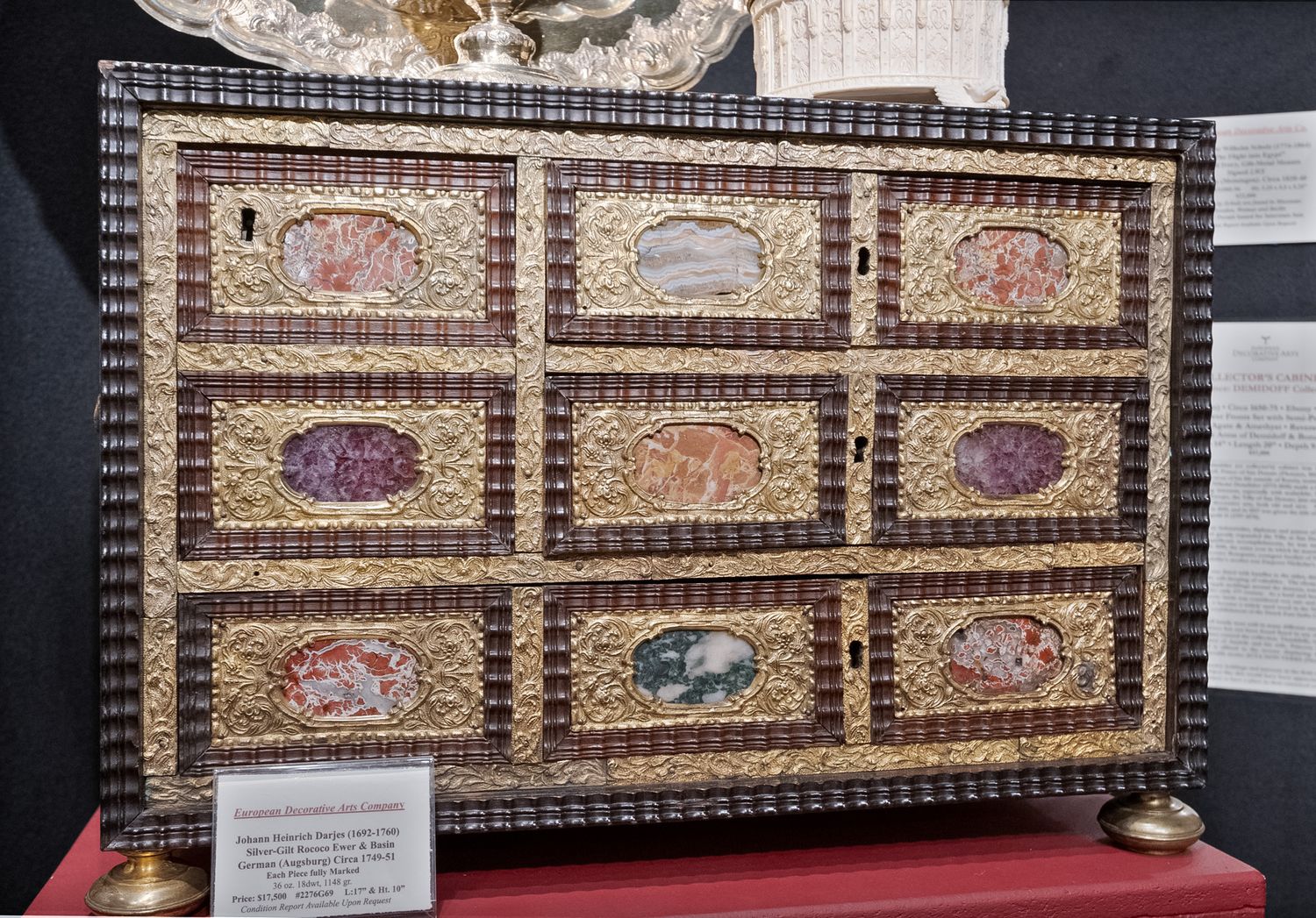 Antique decorative cabinet with painted oval medallions and ornate gilded frame details on display.
