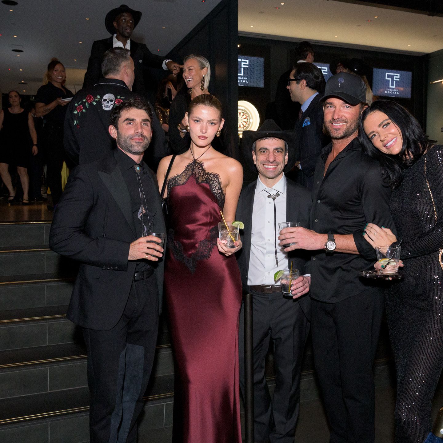Elegantly dressed guests mingle at upscale evening gala.