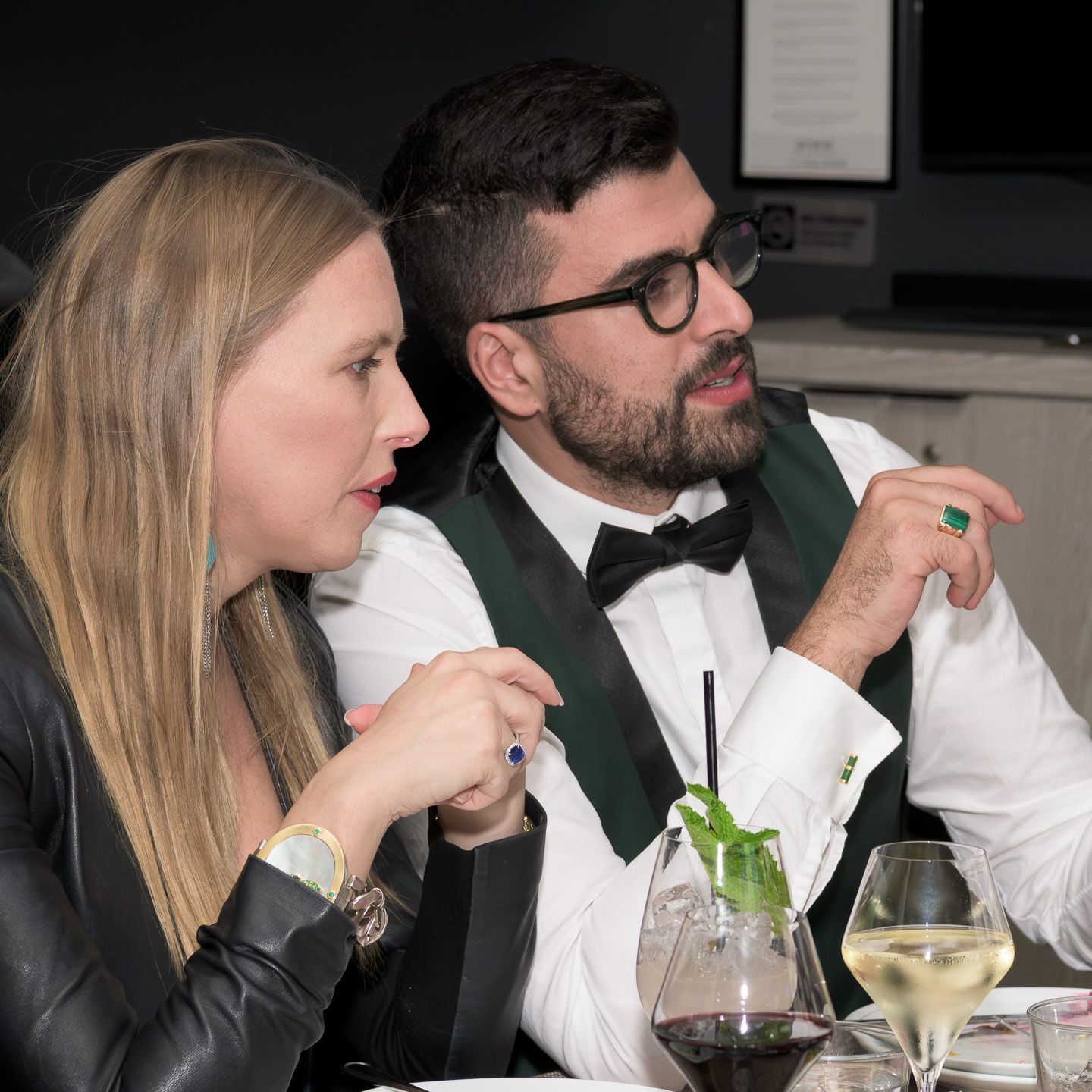 Elegantly dressed couple in formal attire enjoying a gala dinner event together.
