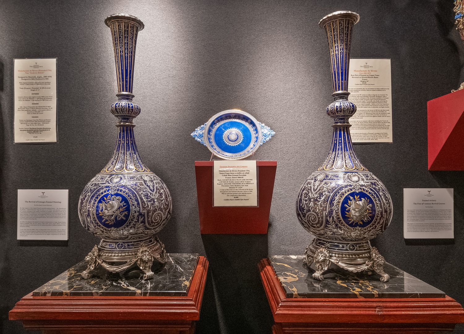 Pair of ornate blue and silver decorative vases on display in museum exhibition.