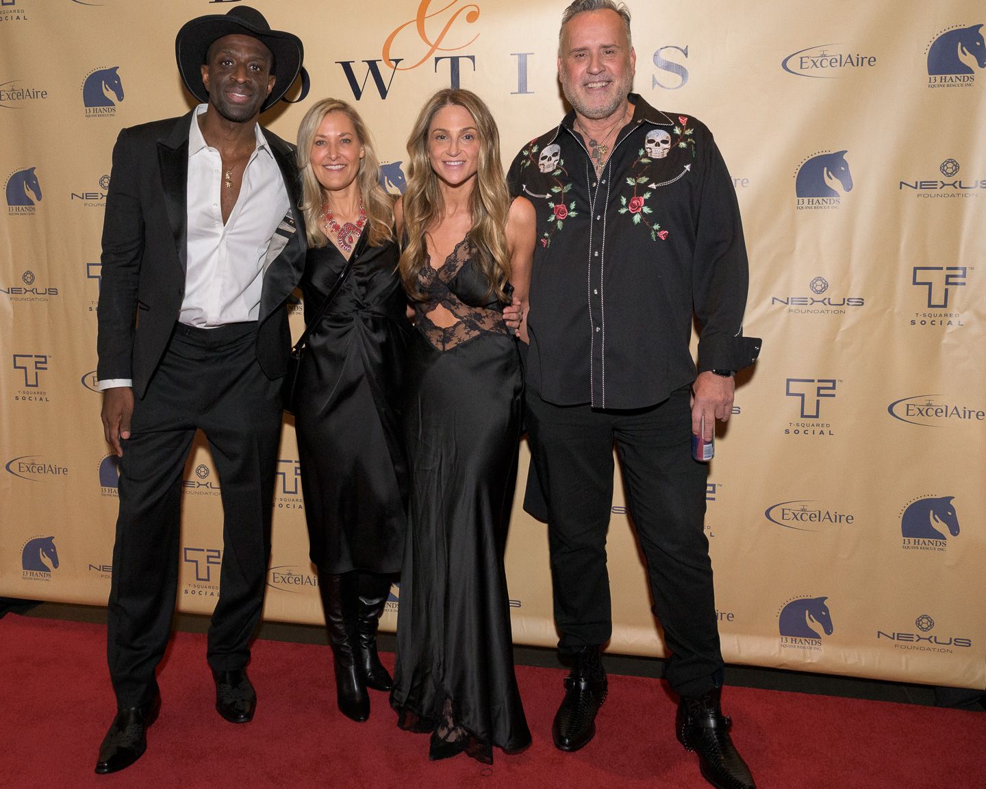 Four guests pose together on red carpet at Bridles event.