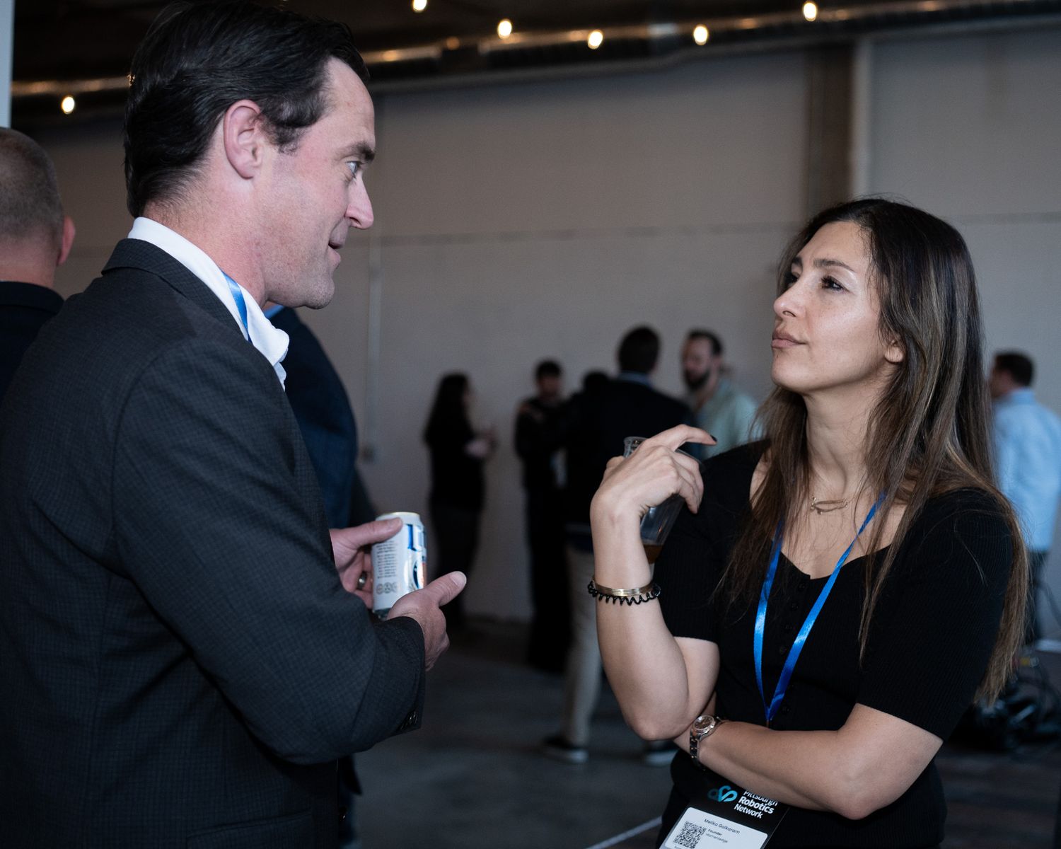Man and woman engaged in focused conversation at a professional networking event.