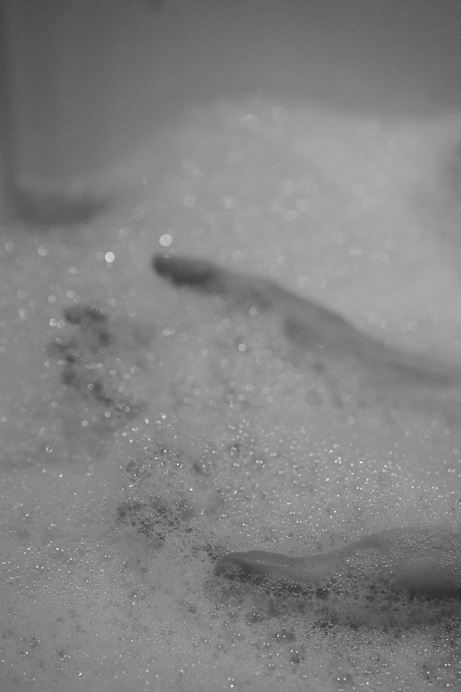 Close-up view of soap bubbles and foam texture in water.