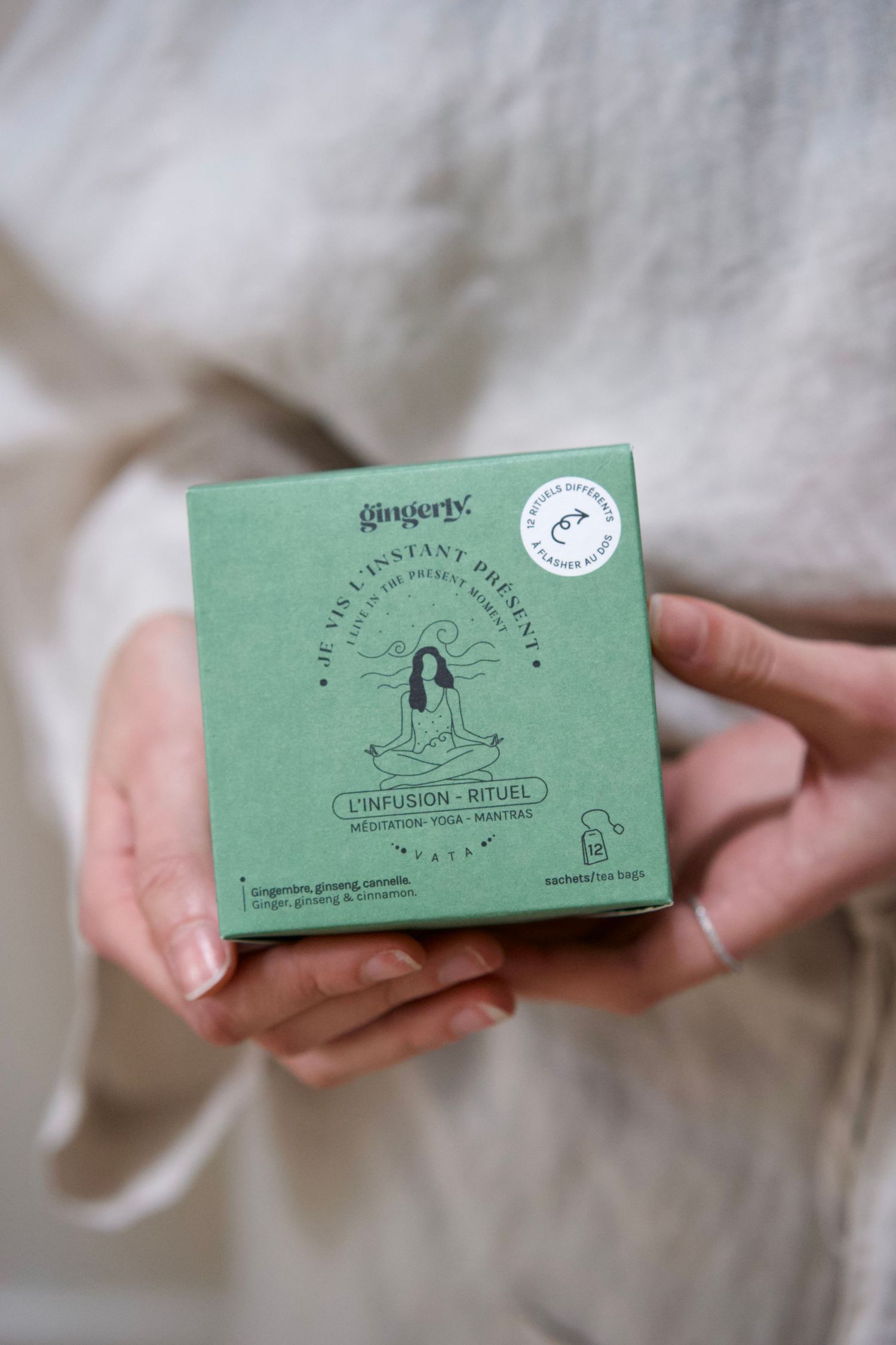 Mint green business card held against white fabric showing minimalist design.
