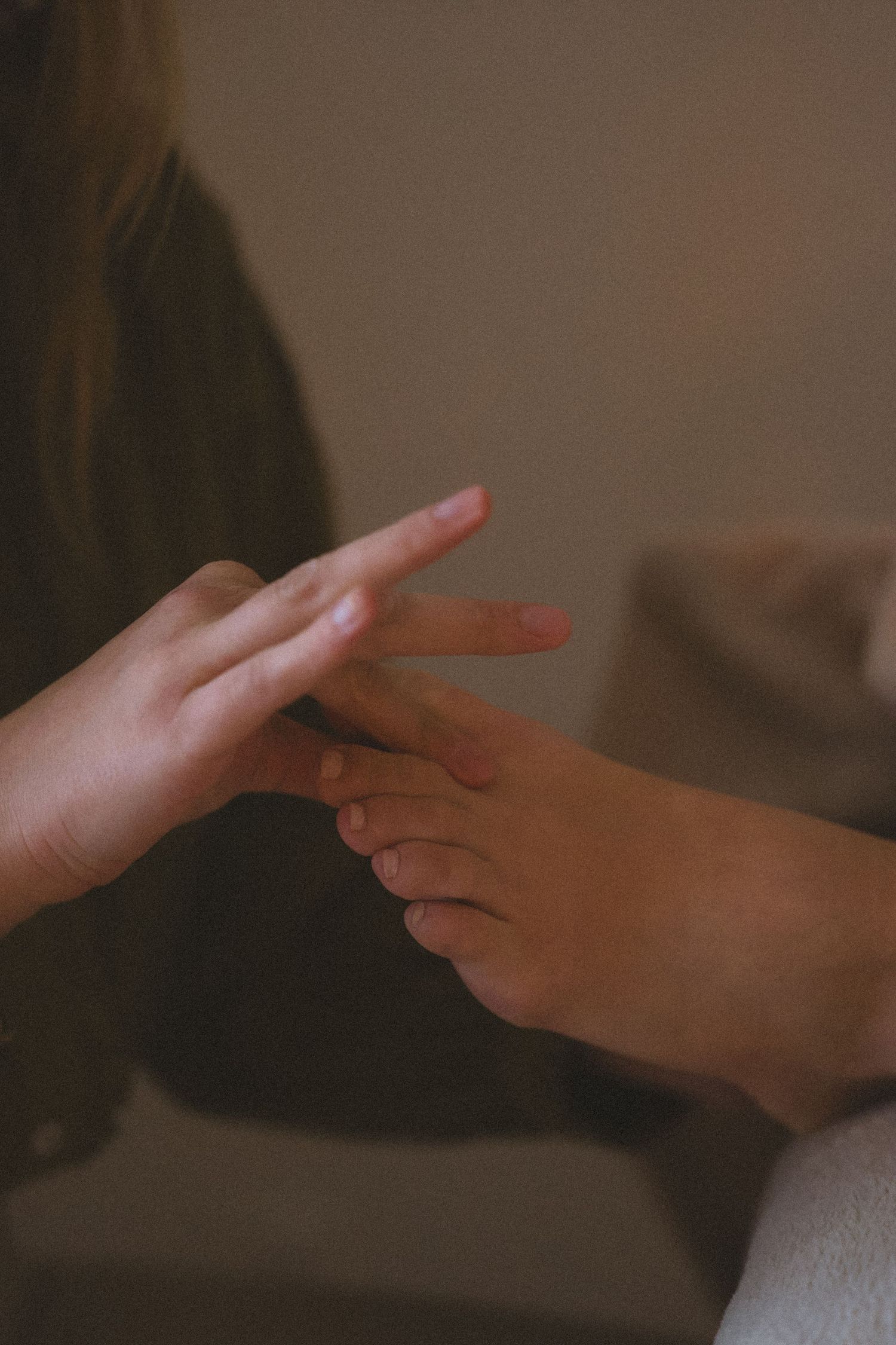 A series of hands playing rock paper scissors against each other in a dimly lit room.