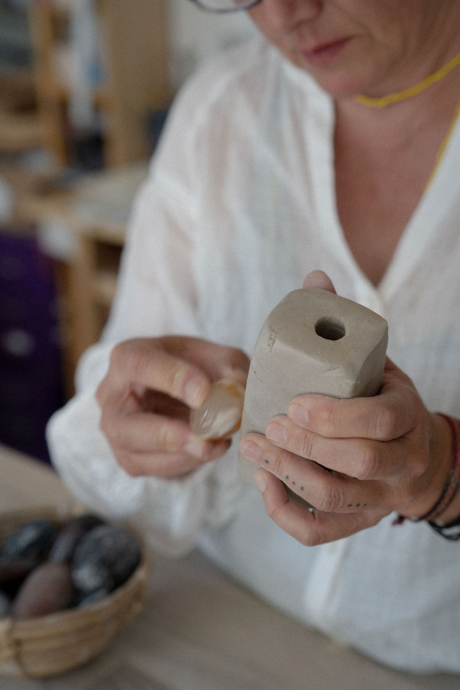 Close-up sequence of hands working with clay pottery showing detailed craftsmanship and shaping techniques.