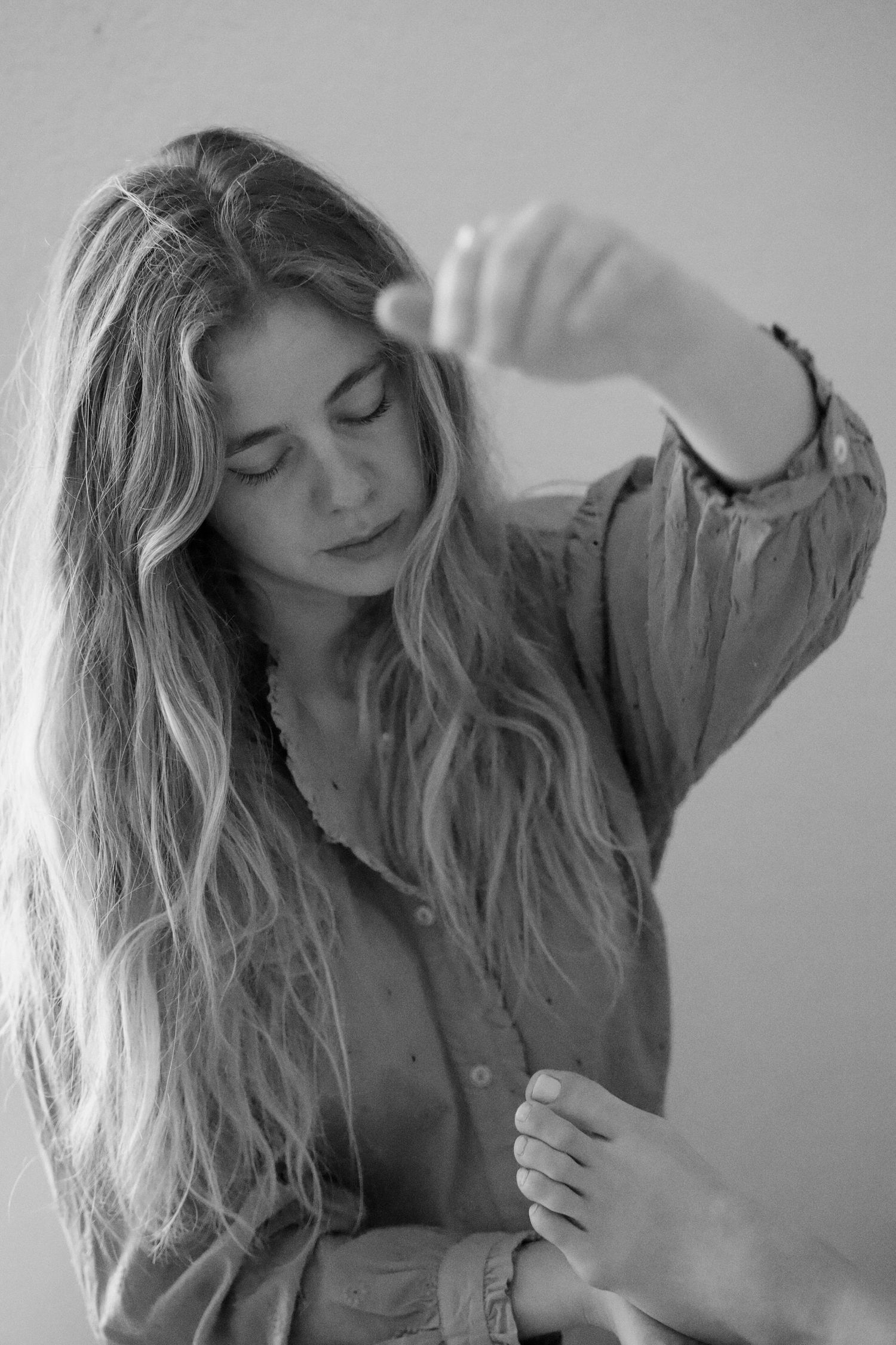 Black and white artistic portrait series showing flowing blonde hair movement against light background.