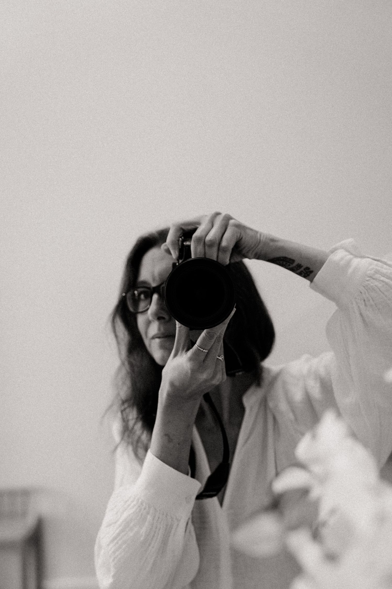 Black and white sequence showing someone using a camera in dramatic lighting.