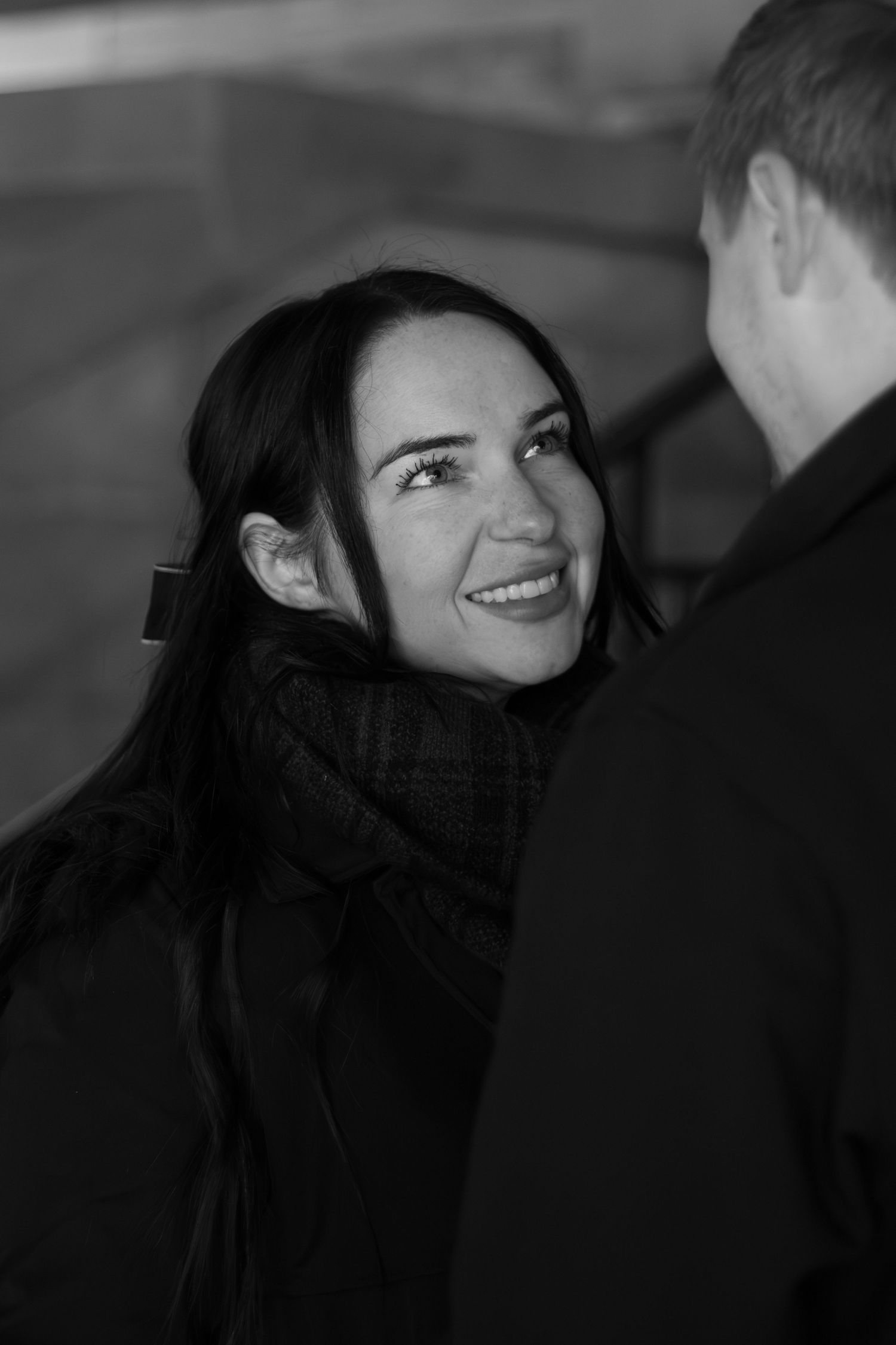 Cute couple smiling at each other during a couples session at downtown Bentonville Arkansas