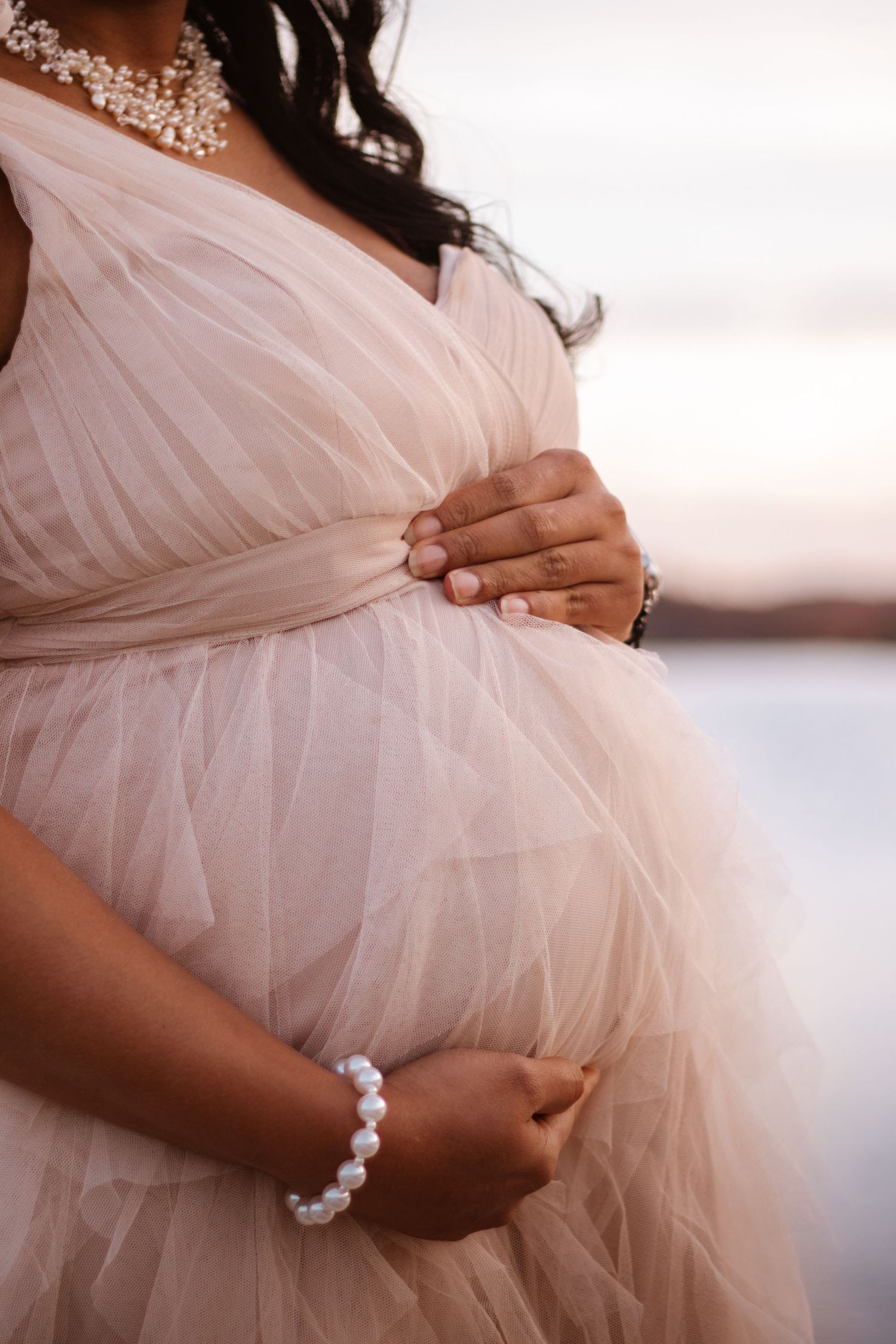Outdoor maternity photoshoot with expecting mother holding belly in Bentonville Arkansas