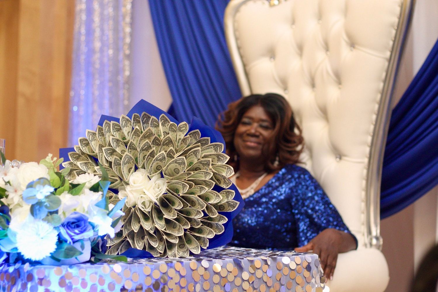Elegant event setup with blue drapes and silver balloon decorations.