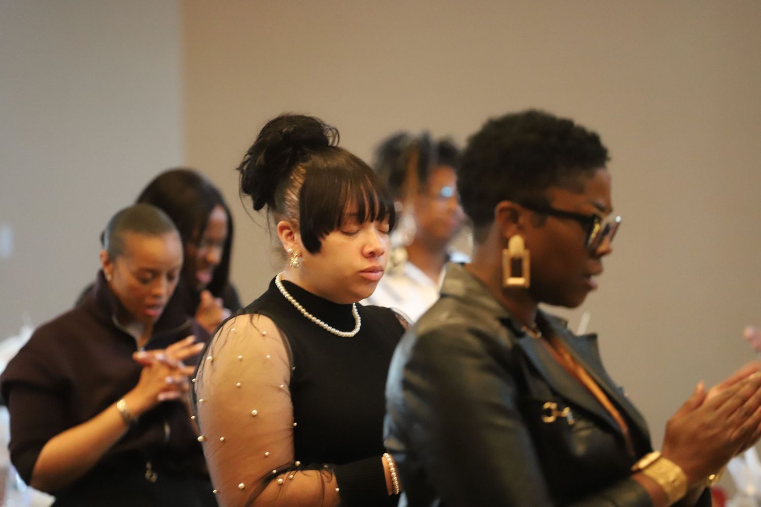 People gathered in formal attire at an indoor celebration event.
