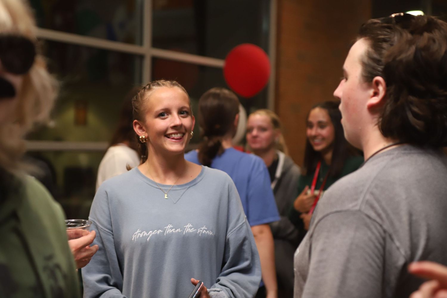 Group of people having an animated conversation at an indoor social gathering.