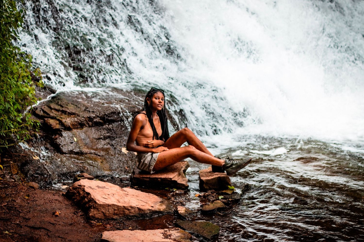 Cascading waterfall flowing over rocky ledges in a natural setting.