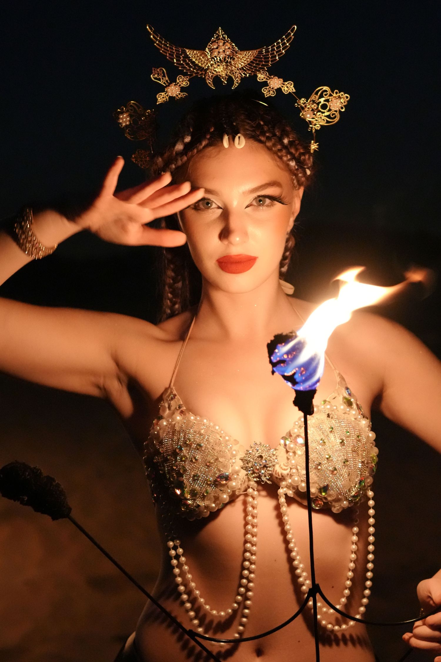 Artistic photo series of a mannequin wearing pearls and butterfly decorations illuminated by candlelight in dark setting.