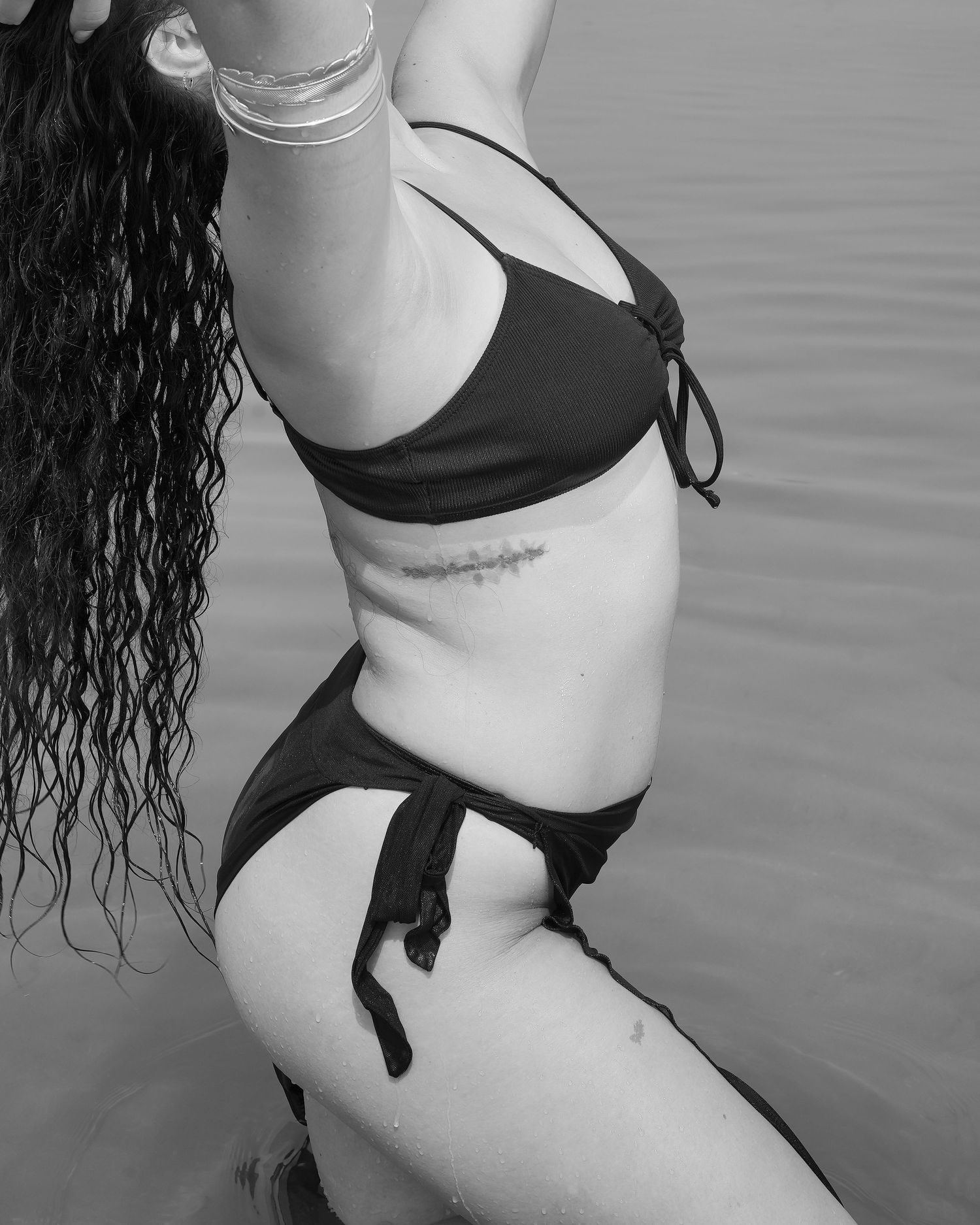 Black and white artistic photo series showing close-up views of a woman in lingerie posing against a minimalist background.