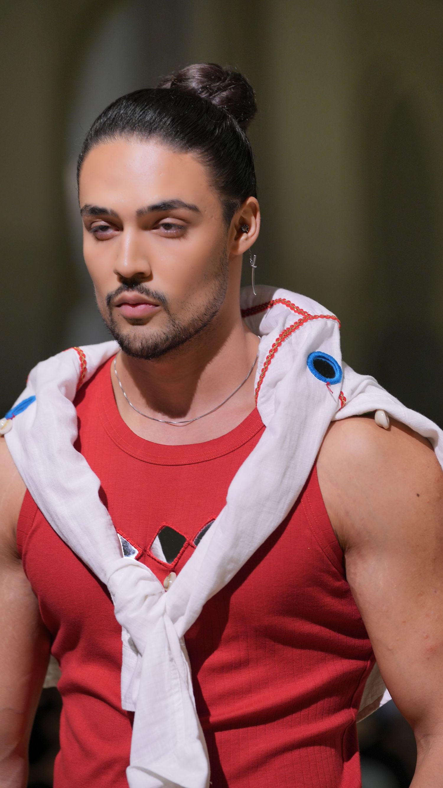 A person in a red tank top and white jacket poses for a series of close-up photos showing different facial expressions.